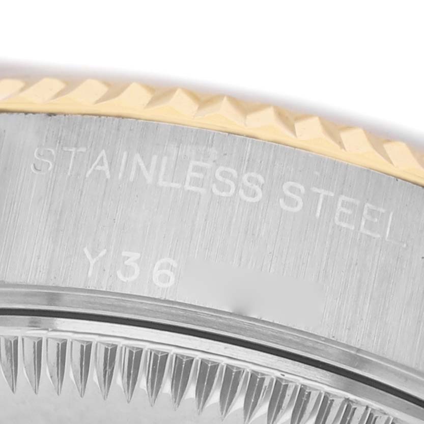 The image shows a close-up of the bezel and side engraving on a Rolex Datejust 79173 Women's Steel and Gold (two tone) White Dial, highlighting its stainless steel and gold trim.
