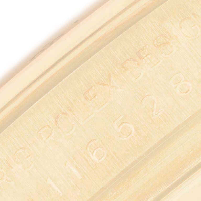 The image shows a close-up of the engraved side of the bezel or case of a Rolex Daytona 116528 Men's Yellow Gold White Dial 116528 Men's Yellow Gold White Dial watch.