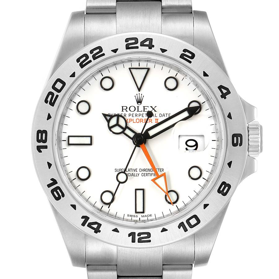 The image shows a Rolex Explorer II watch face from a straight-on angle, highlighting the dial, bezel, and part of the bracelet.