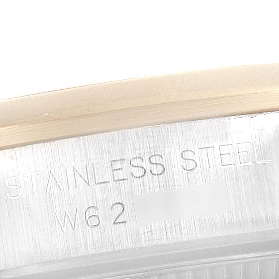 The image shows a close-up of the engraved stainless steel part of a Rolex Oyster Perpetual 67183 Women's Steel and Gold (two tone) Champagne Dial 67183 Women's Steel and Gold (two tone) Champagne Dial watch.