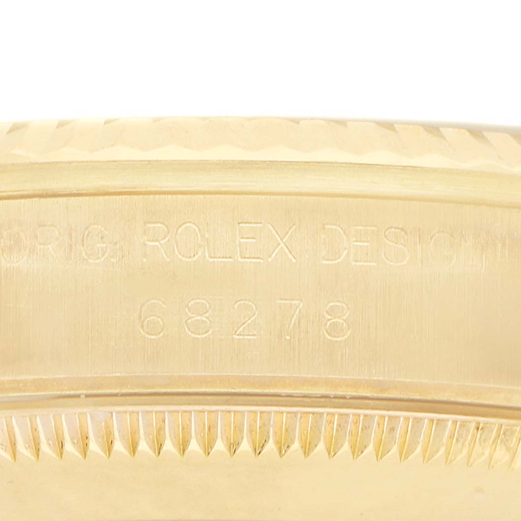 The image shows a close-up of the side of a Rolex President 68278 Women's Yellow Gold White Dial model, focusing on the engraving and fluted bezel.