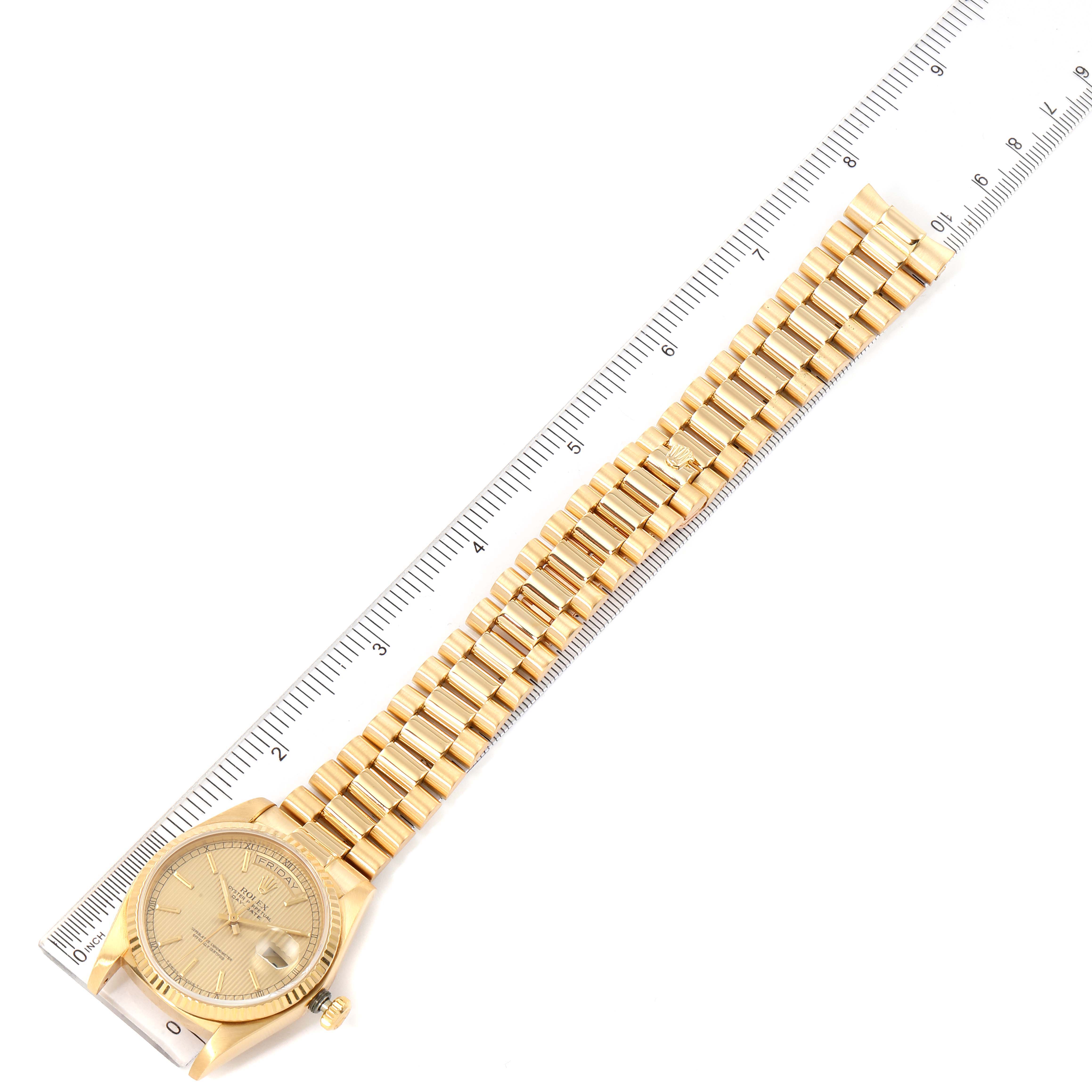 The image shows a top-down view of a Rolex President 18038 Men's Yellow Gold Champagne Dial 18038 Men's Yellow Gold Champagne Dial model watch with its gold bracelet, alongside a ruler for scale.