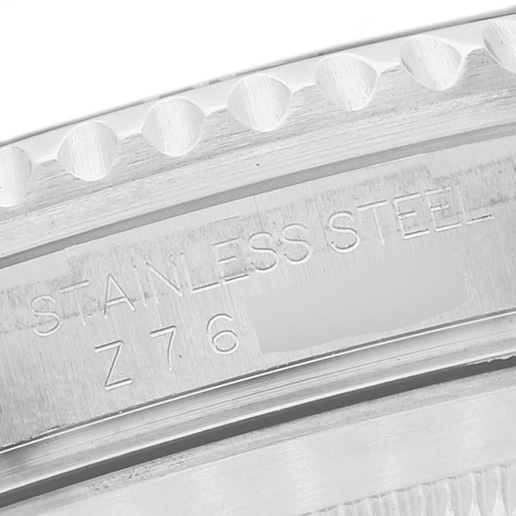 This close-up image shows the side of the bezel and the case of a Rolex Submariner 16610T Men's Stainless Steel Black Dial 16610T Men's Stainless Steel Black Dial watch, highlighting the stainless steel marking and serial number.