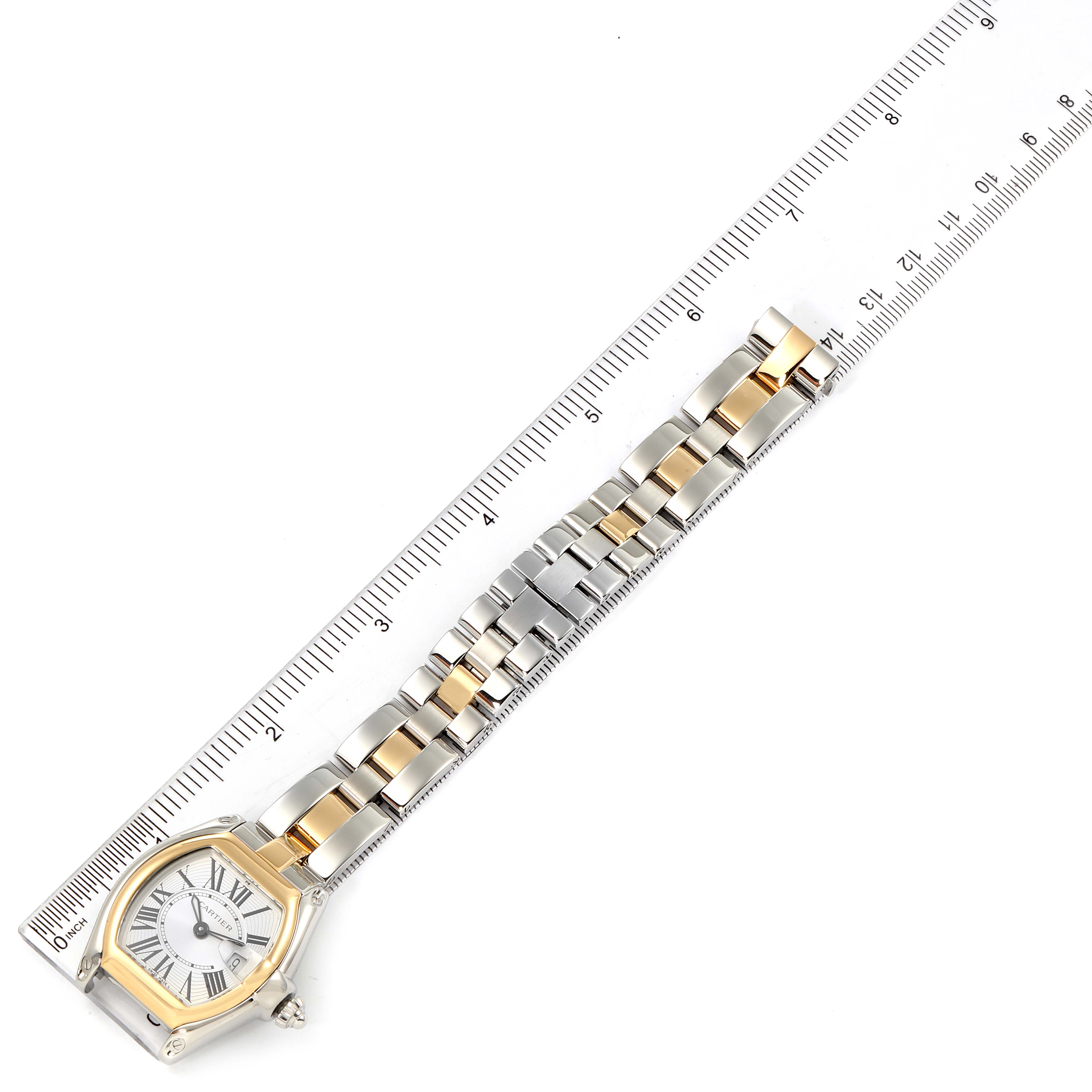 The Cartier Roadster W62026Y4 Women's Steel and Gold (two tone) Silver Dial W62026Y4 Women's Steel and Gold (two tone) Silver Dial watch is shown from an overhead angle with a ruler alongside its two-tone metal bracelet.