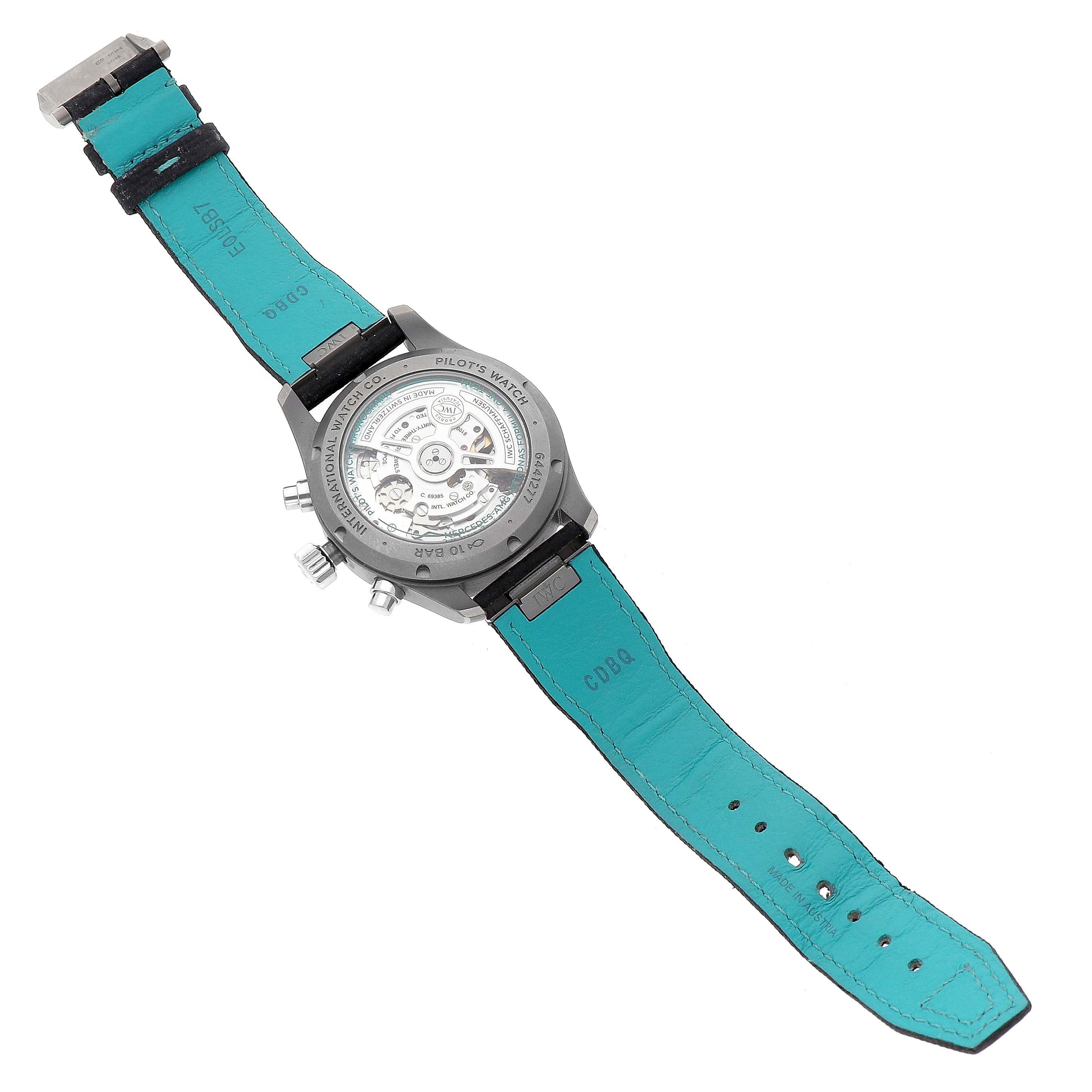 The IWC Pilot IW388114 Men's Titanium Black Dial watch is shown from the back, displaying its open case back and turquoise strap interior.