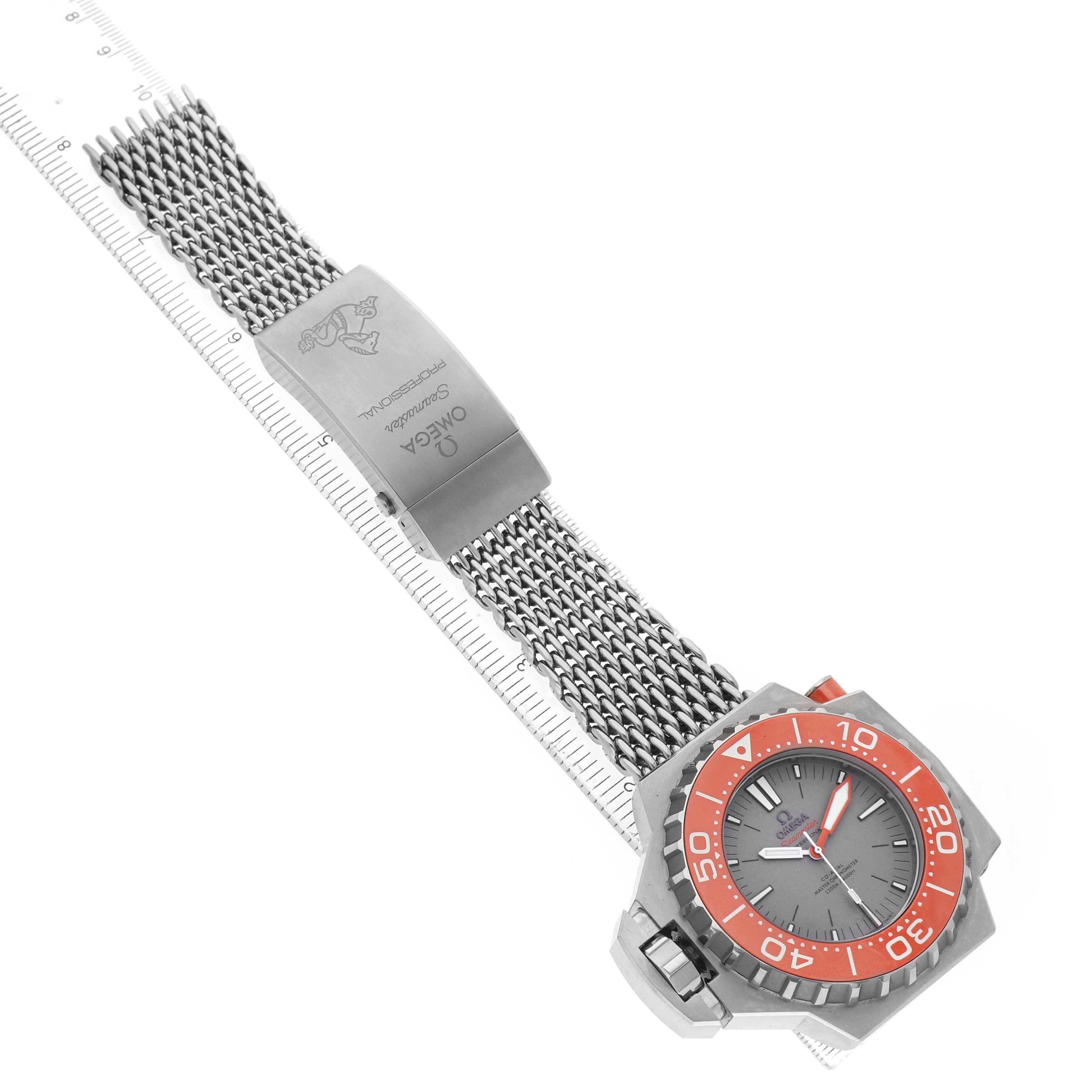 The Omega Ploprof 227.90.55.21.99.002 Men's Titanium Grey Dial watch is shown from a top-down angle, highlighting its metal mesh strap, clasp, and orange bezel.