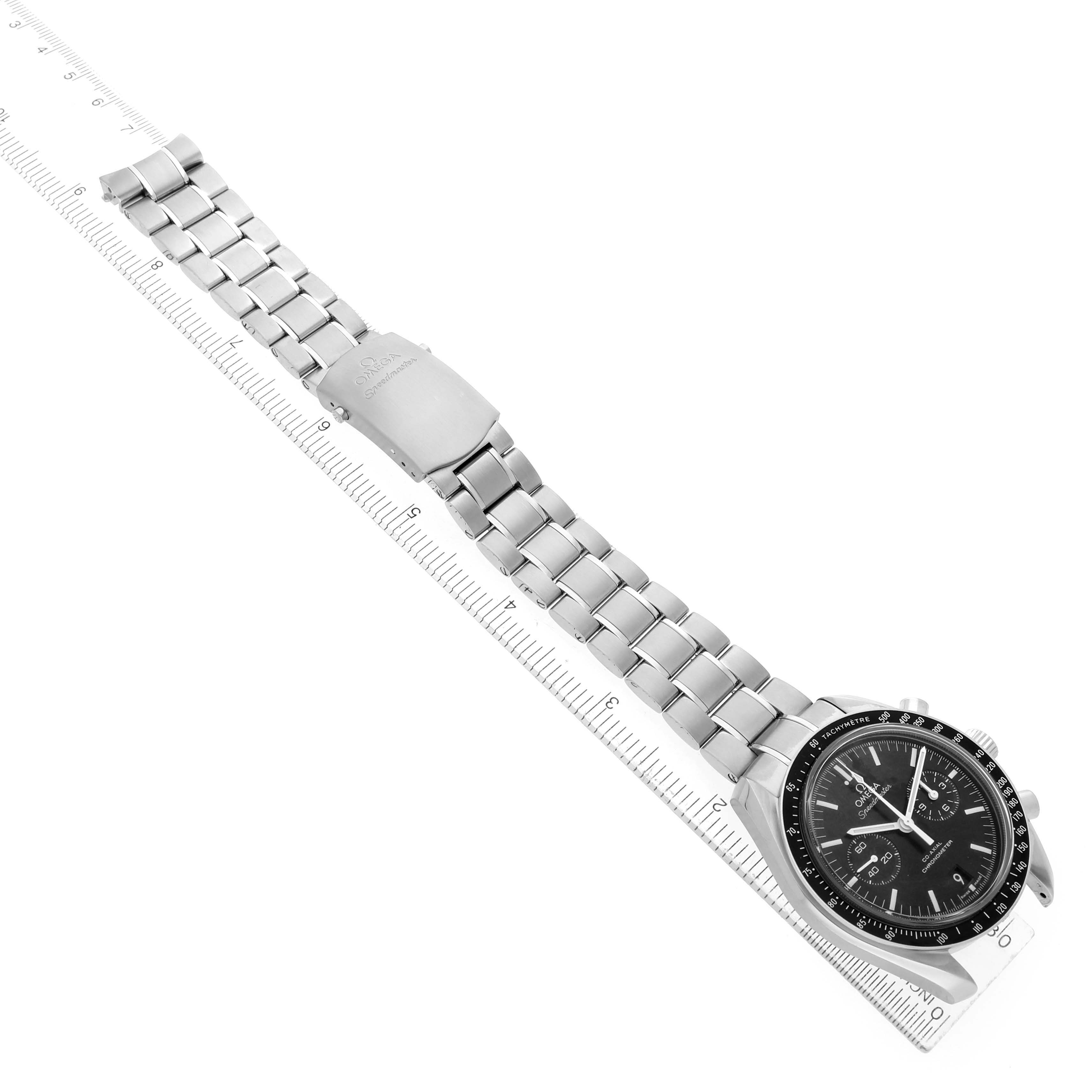 The Omega Speedmaster 311.30.44.51.01.002 Men's Stainless Steel Black Dial watch is shown at a top angle, displaying the bracelet and side of the case with a ruler for scale.