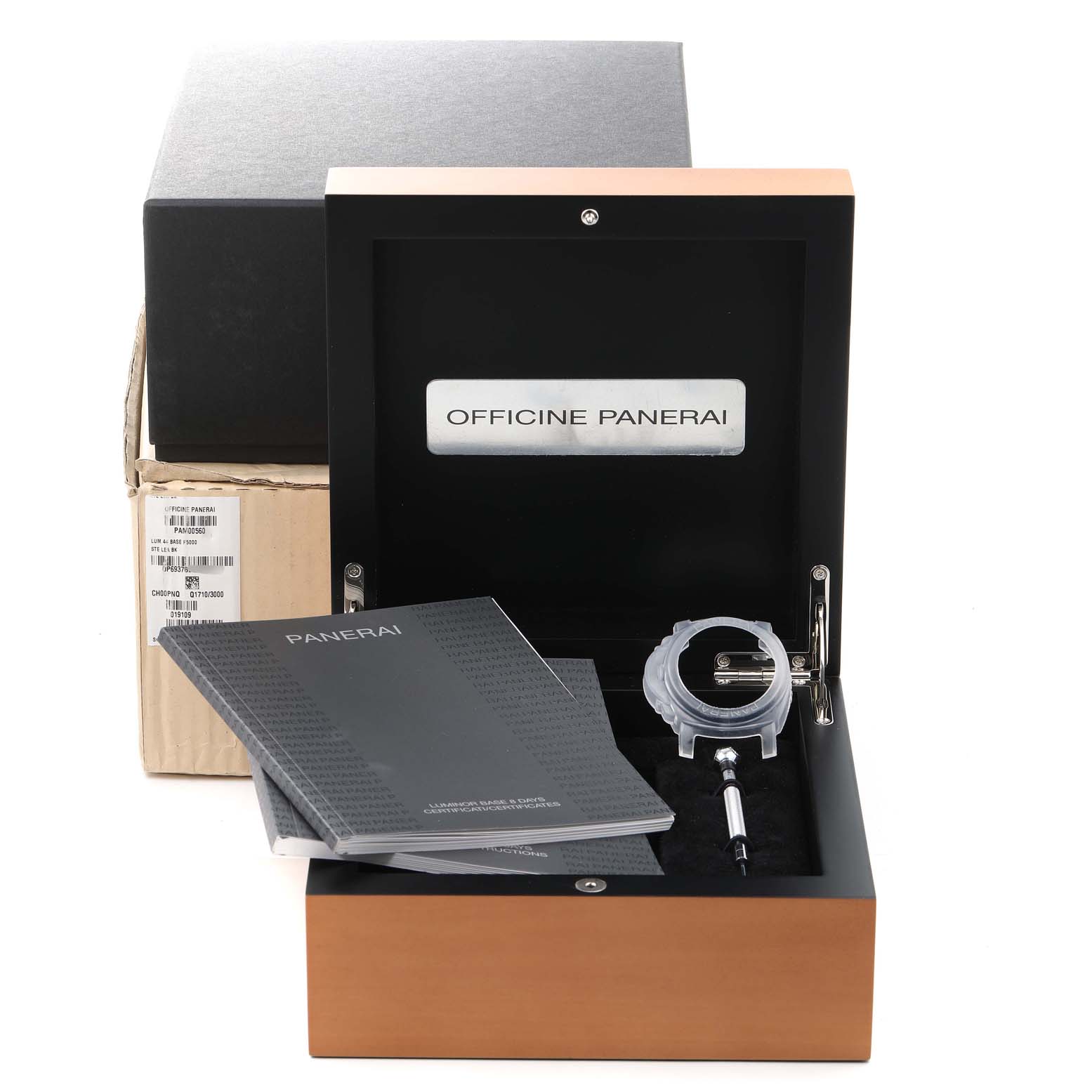 The image shows the open box of a Panerai Luminor PAM00560 Men
s Stainless Steel Black Dial PAM00560 Men
s Stainless Steel Black Dial watch, featuring documentation, a protective case, and tools.