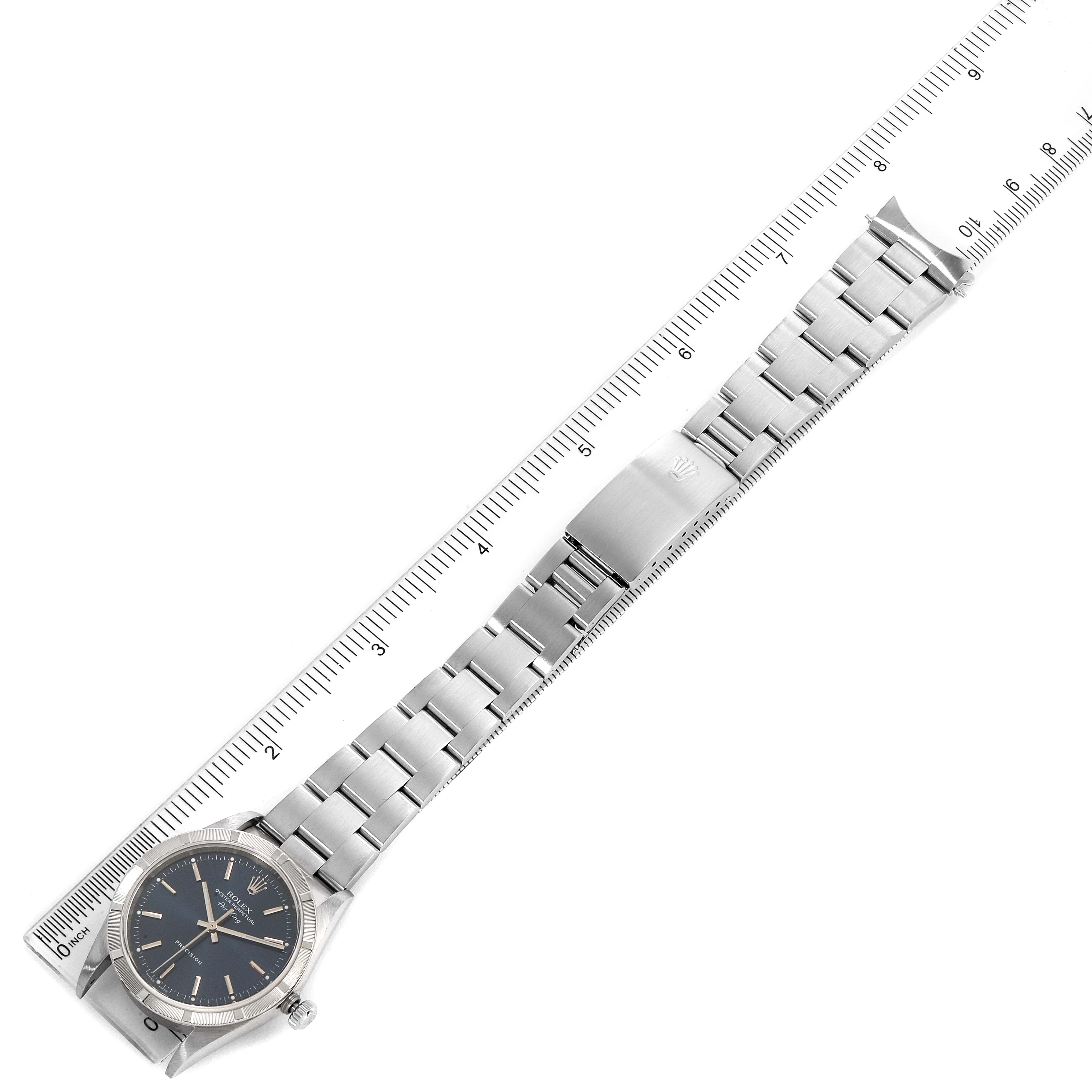 This image shows a Rolex Air-King 14010 Men's Stainless Steel Blue Dial 14010 Men's Stainless Steel Blue Dial watch placed diagonally next to a ruler, displaying its full length and bracelet.
