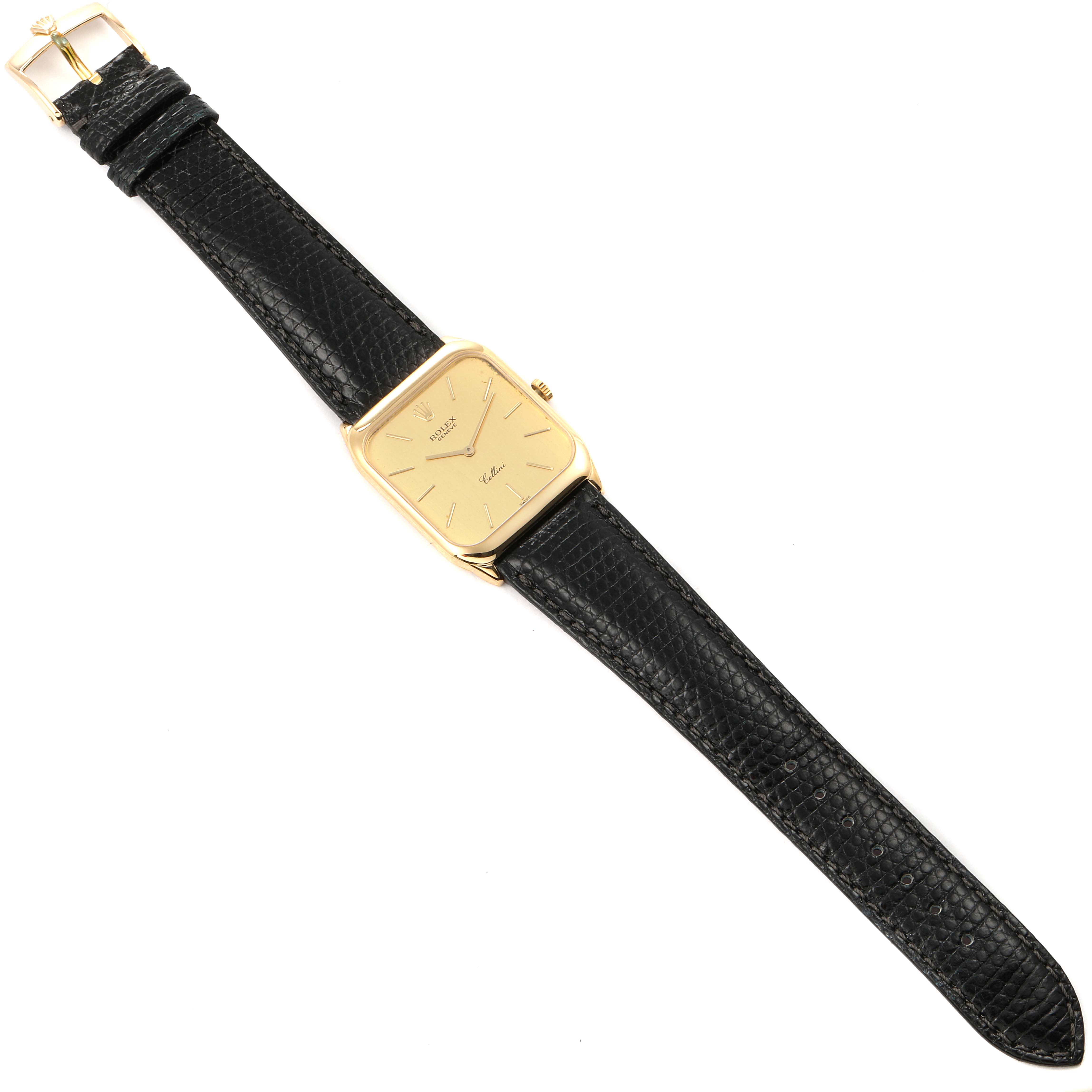 The Rolex Cellini 4135 Men's Yellow Gold Champagne Dial 4135 Men's Yellow Gold Champagne Dial watch is shown from a top view displaying its black strap, gold case, and face.