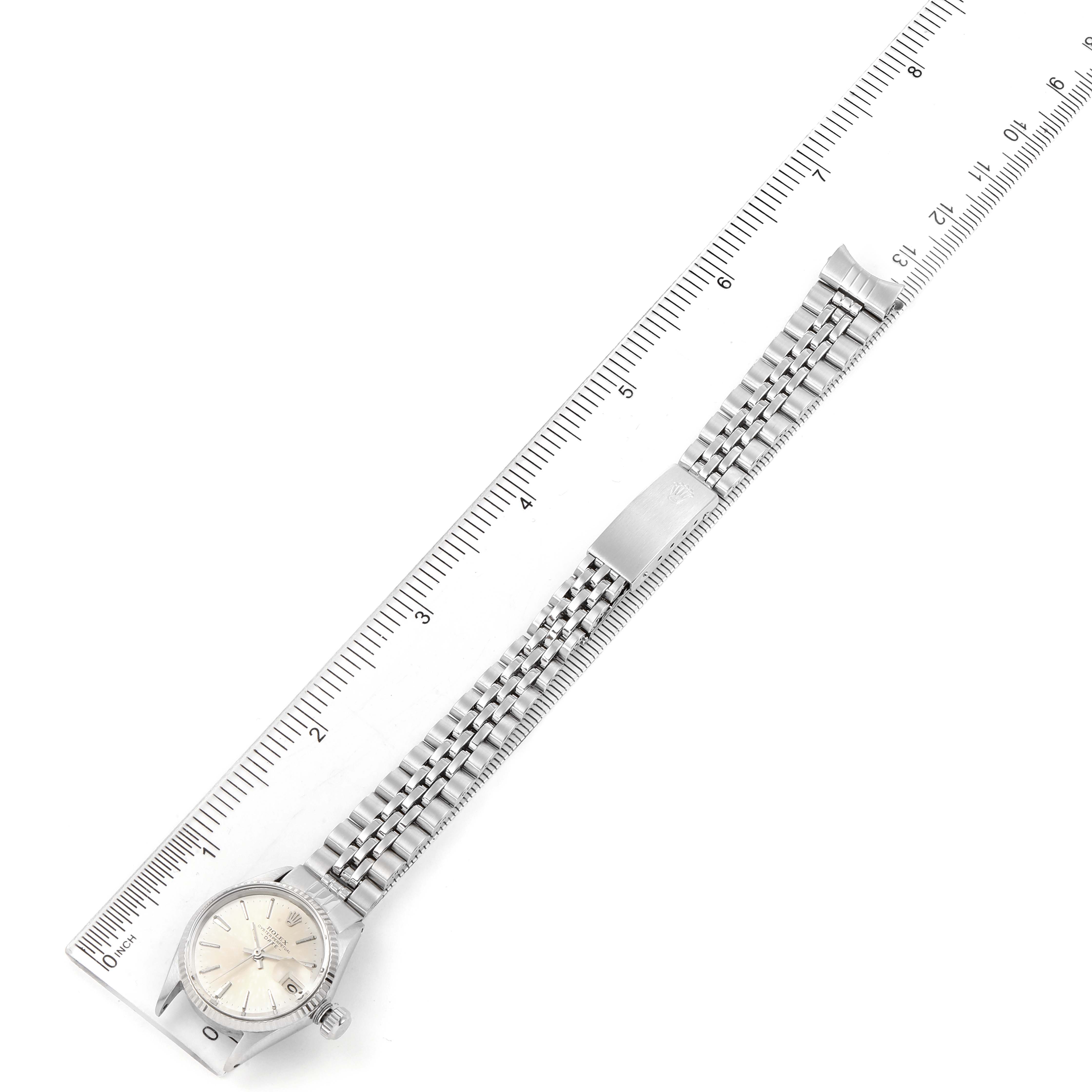 This image shows a Rolex Date 6517 Women's Stainless Steel Silver Dial 6517 Women's Stainless Steel Silver Dial model watch laid flat with its entire band next to a ruler for scale.