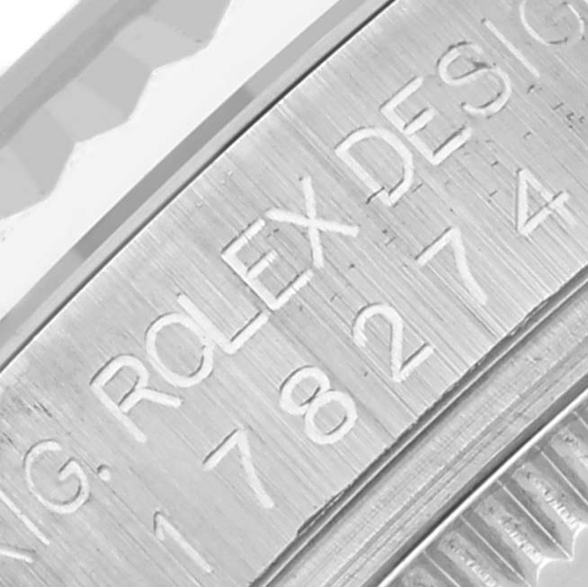 The image shows an angled close-up of a Rolex Mid-Size 178274 Women's Stainless Steel Pink Dial 178274 Women's Stainless Steel Pink Dial watch's engraved bezel with serial and model numbers.