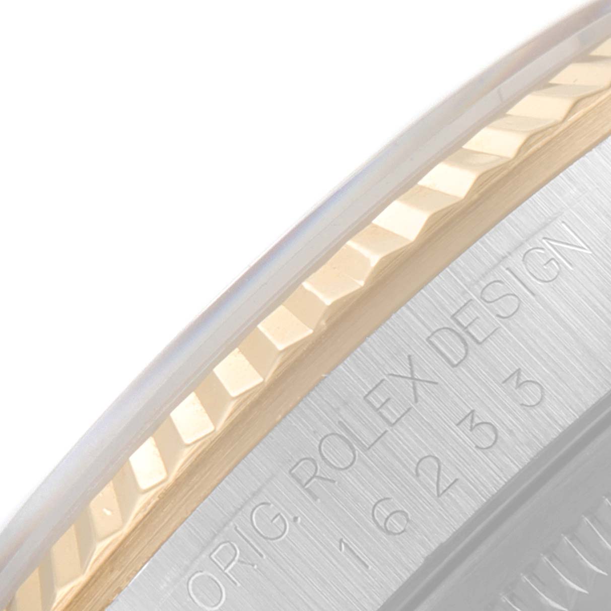 The image shows a close-up of the fluted bezel and engraved edge of a Rolex Datejust 16233 Men's Steel and Gold (two tone) Blue Dial 16233 Men's Steel and Gold (two tone) Blue Dial watch.