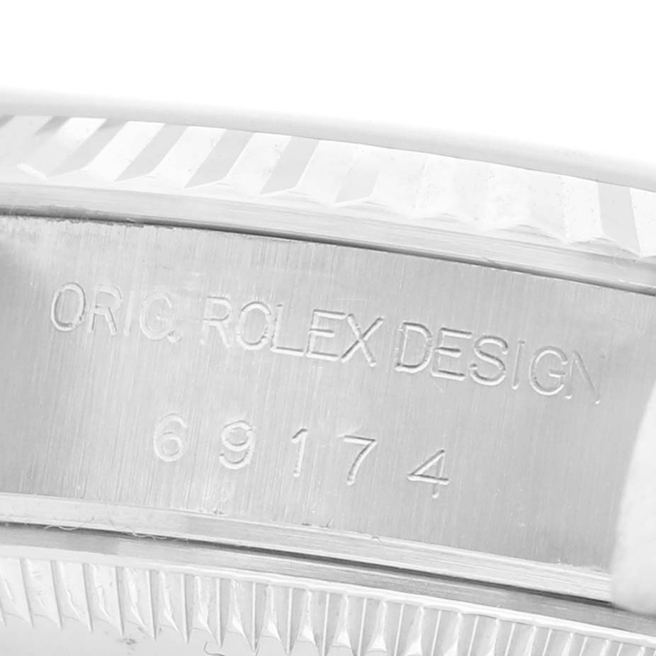 The image shows a close-up of the side of a Rolex Datejust 69174 Women's Stainless Steel Silver Dial watch, highlighting the model number and design engraving.
