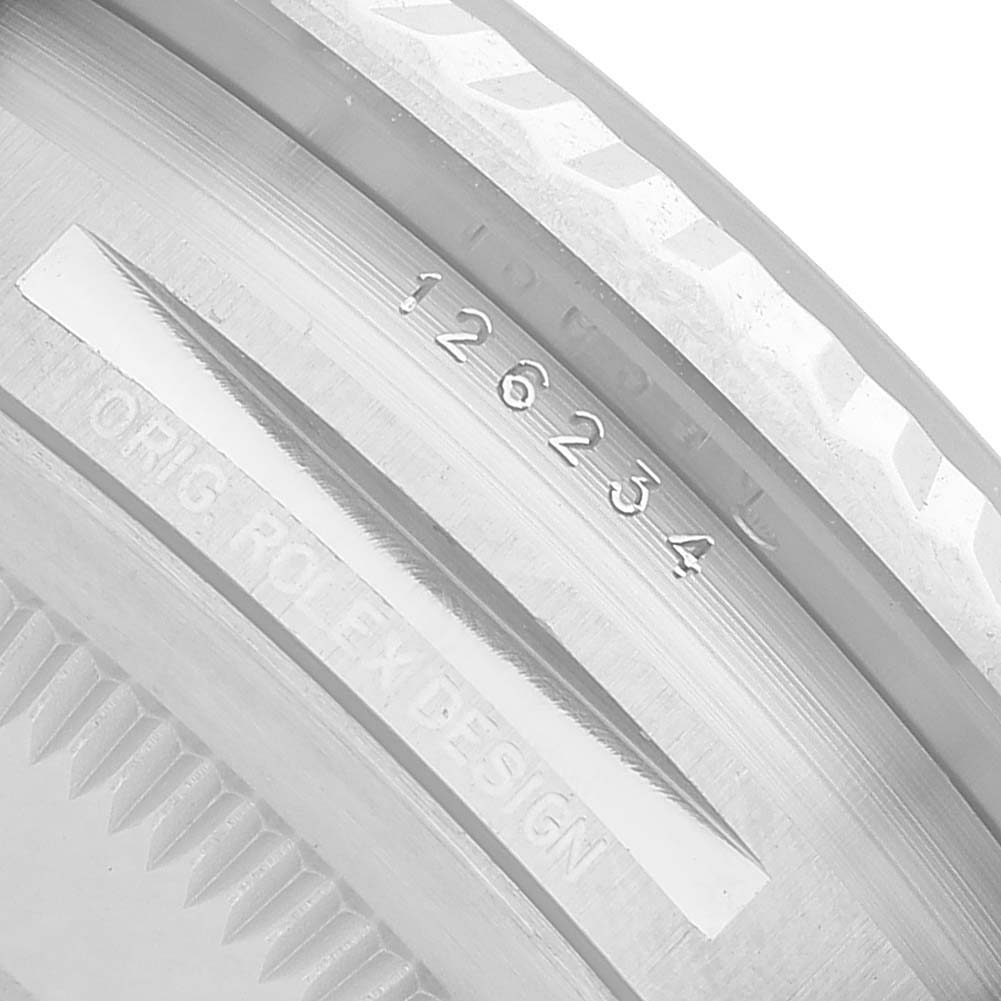 The image shows a close-up view of the Rolex Datejust 126234 Men's Stainless Steel Blue Dial's serial and model numbers engraved on the case edge.