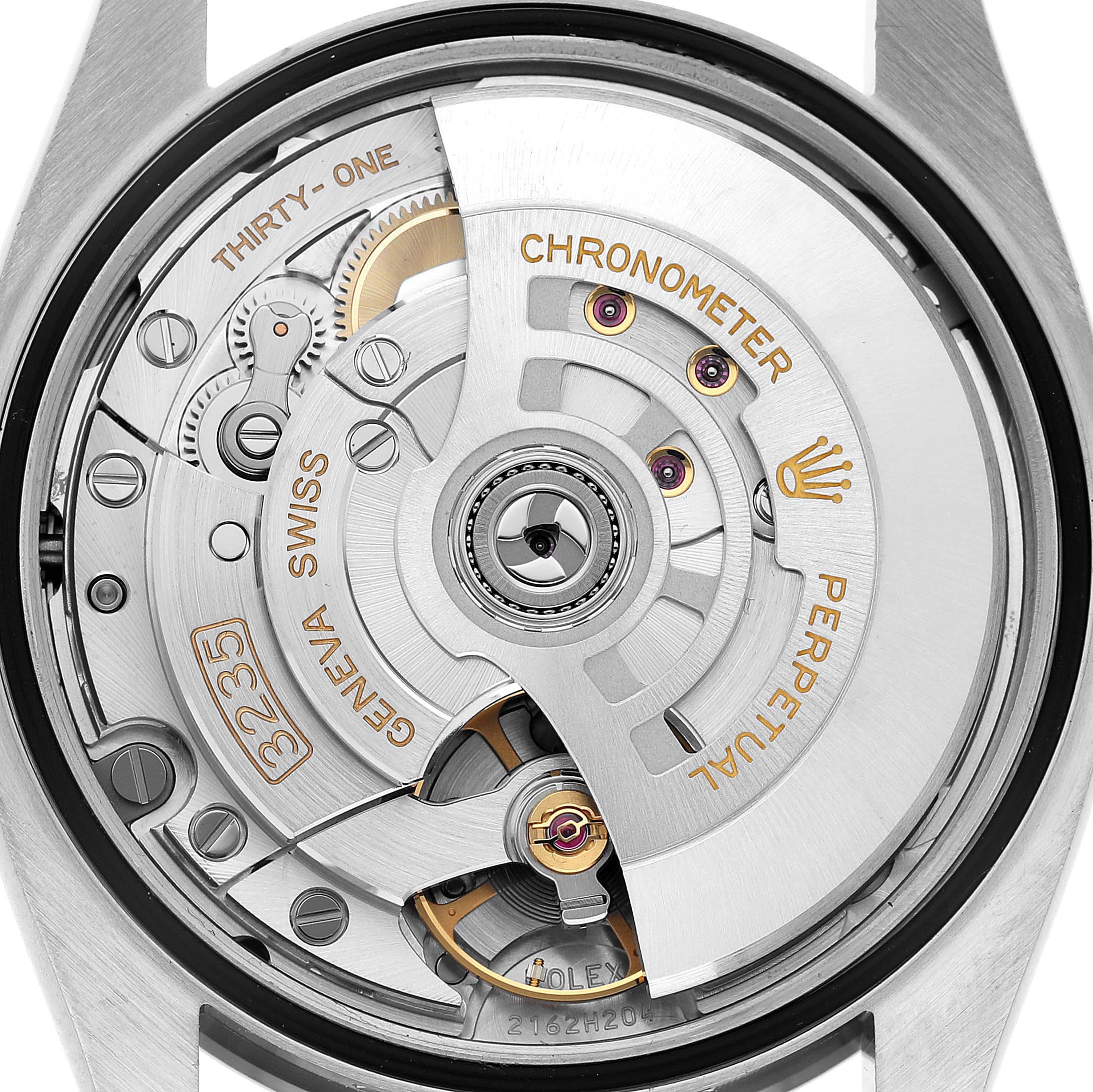 The image shows a close-up of the movement inside the Rolex Datejust 126234 Men's Stainless Steel Blue Dial, highlighting gears and the rotor.