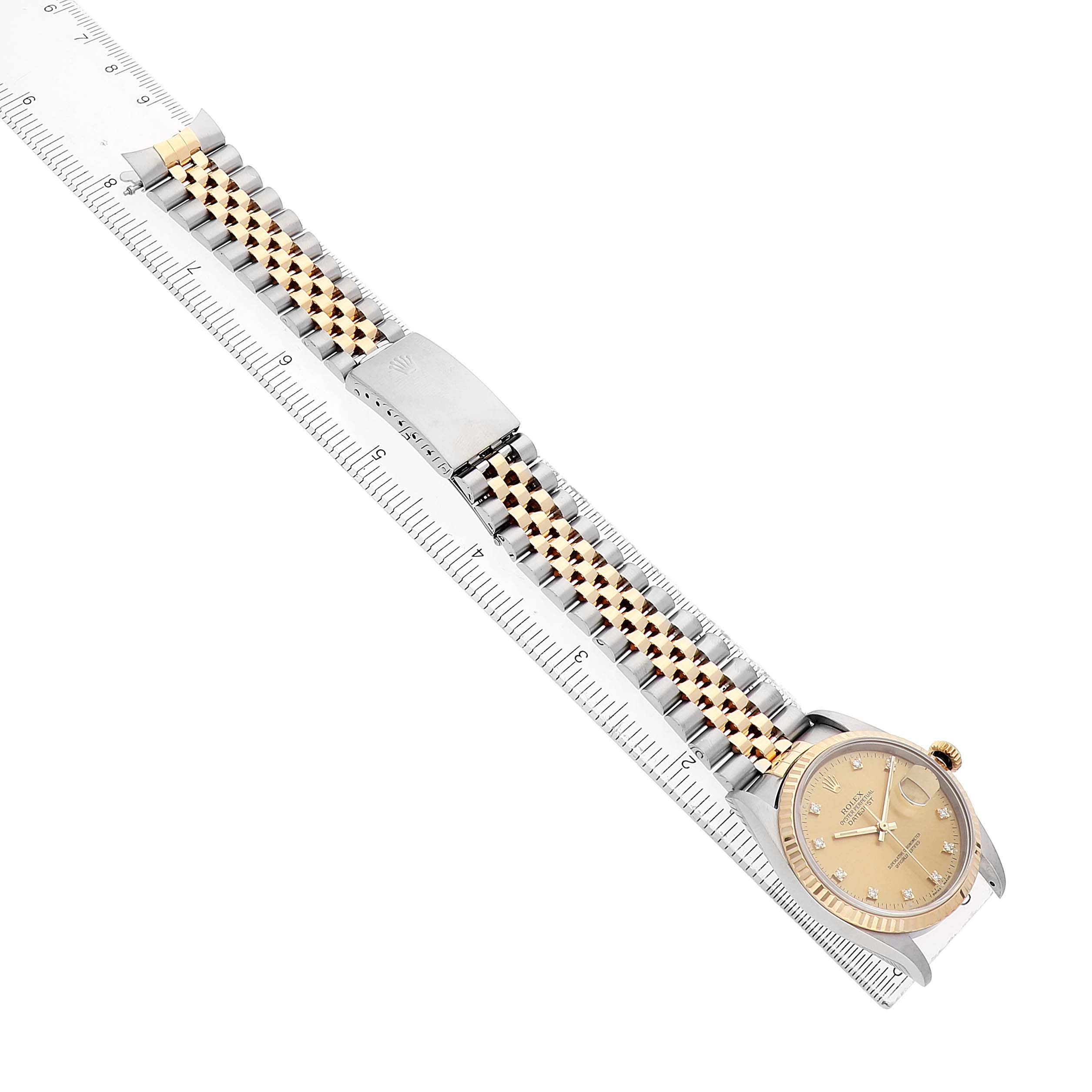The Rolex Datejust 16233 Men's Stainless Steel Champagne Dial watch is shown at a diagonal angle, displaying the dial, bracelet, and clasp alongside a ruler for scale.