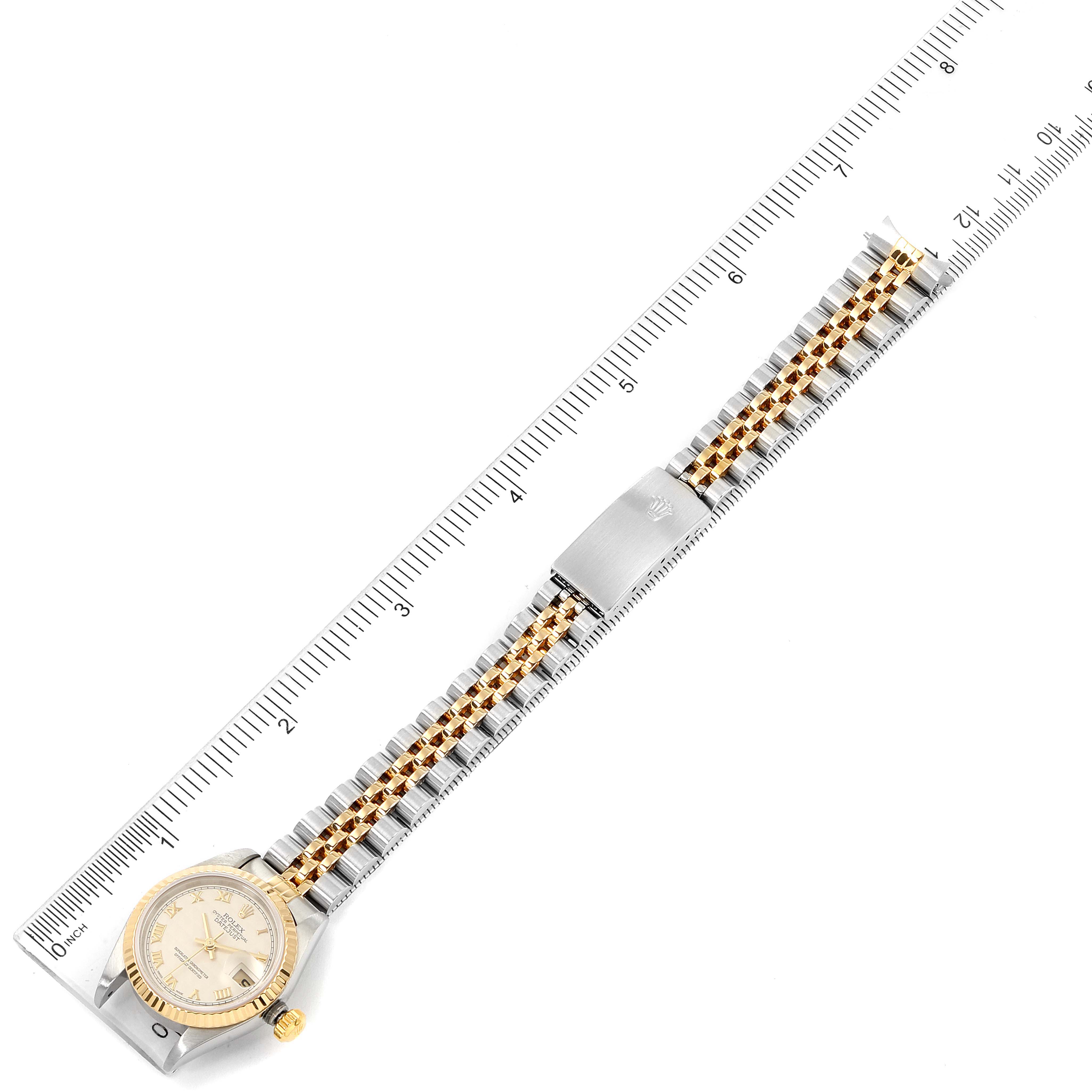 The image shows an overhead view of a Rolex Datejust 79173 Women's Steel and Gold (two tone) Silver Dial 79173 Women's Steel and Gold (two tone) Silver Dial watch, focusing on the watch face, band, and clasp alongside a ruler.
