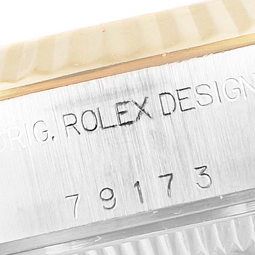 This close-up image shows the engraved serial number and part of the bezel on a Rolex Datejust 79173 Women's Steel and Gold (two tone) Silver Dial 79173 Women's Steel and Gold (two tone) Silver Dial model watch.