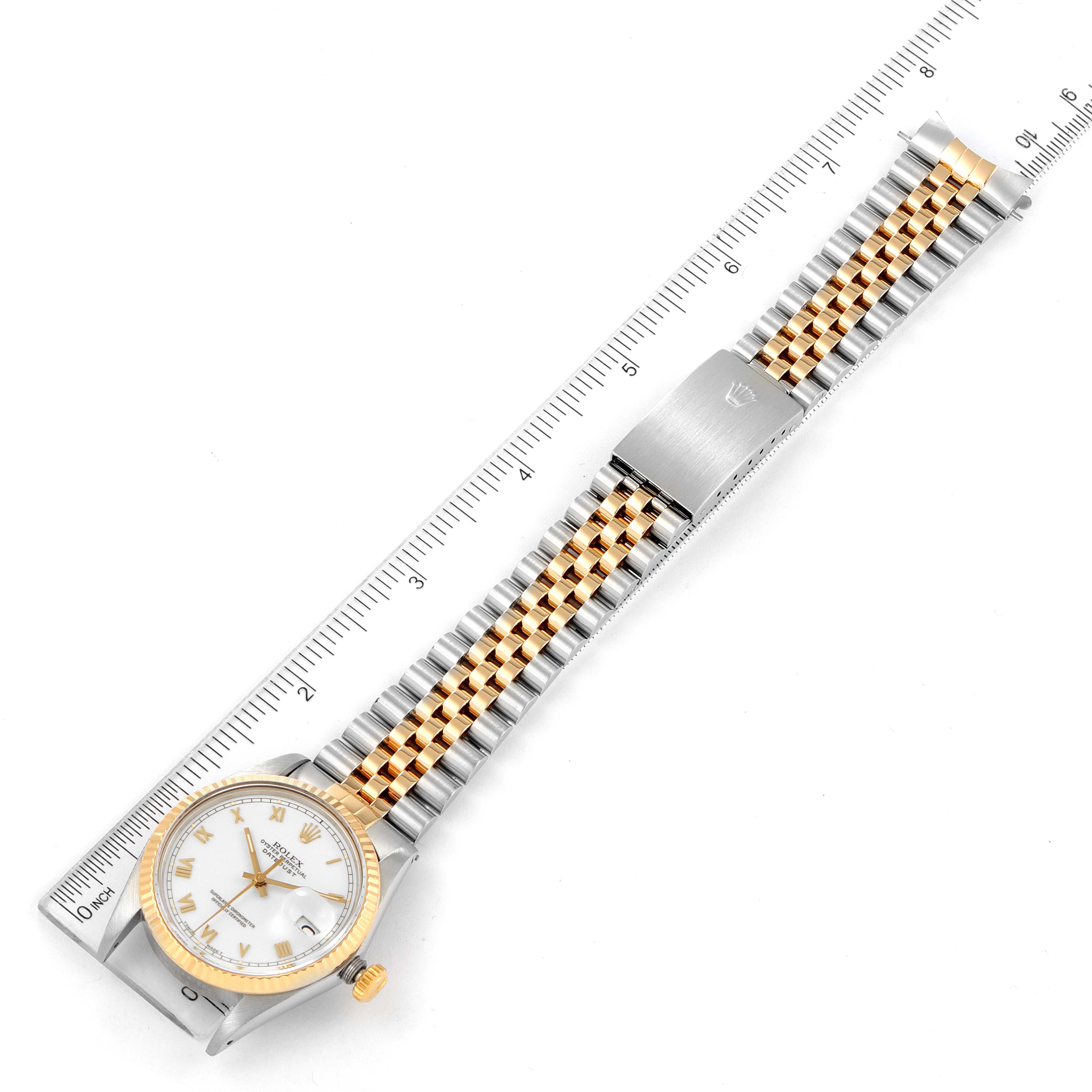 This image shows a top-down view of a Rolex Vintage Collection 16013 Men's Steel and Gold (two tone) White Dial 16013 Men's Steel and Gold (two tone) White Dial watch with a two-tone metal bracelet, laid next to a ruler.