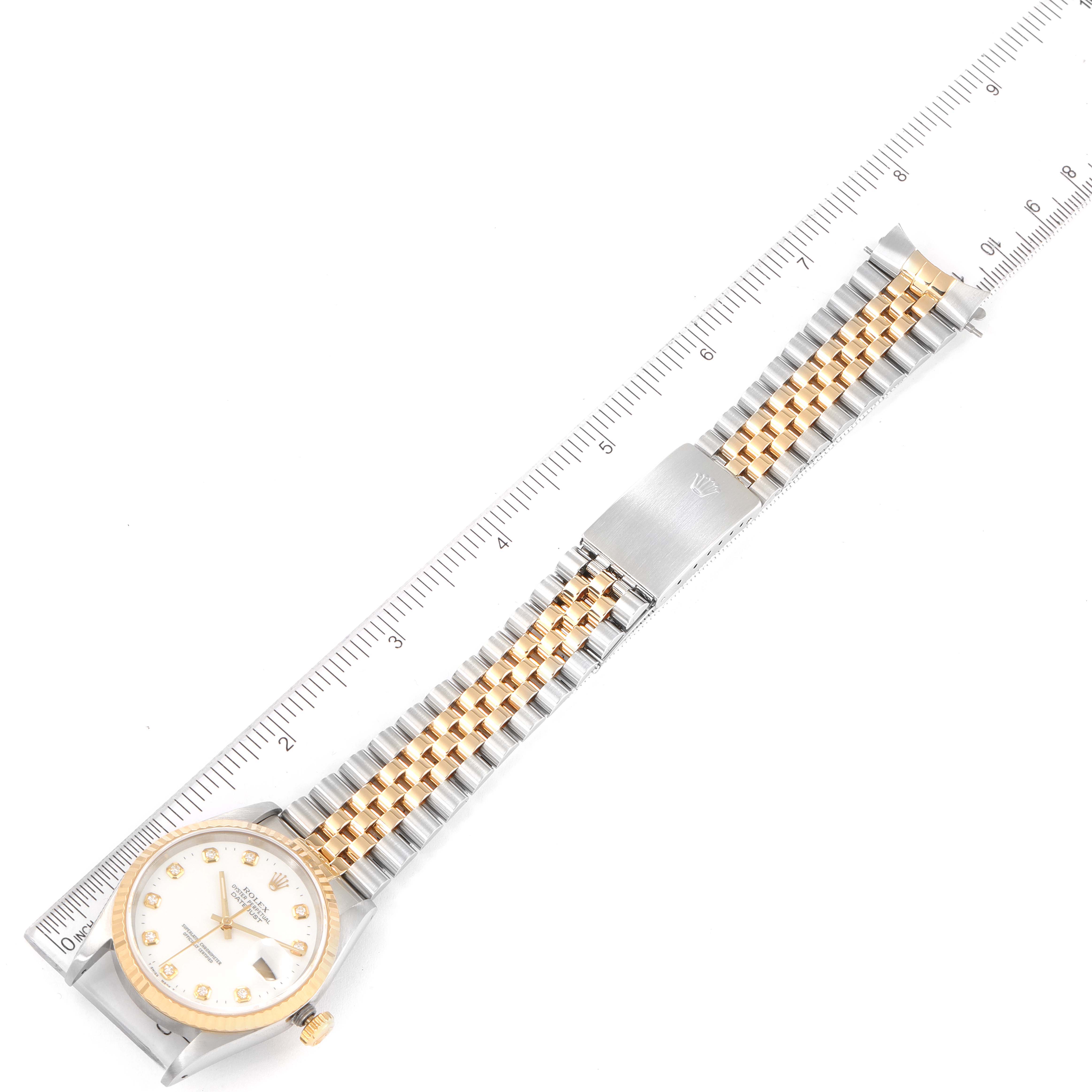 The image shows a Rolex Datejust 16233 Men's Steel and Gold (two tone) White Dial 16233 Men's Steel and Gold (two tone) White Dial watch laid flat with the face, bracelet, and clasp visible, aligned with a ruler.