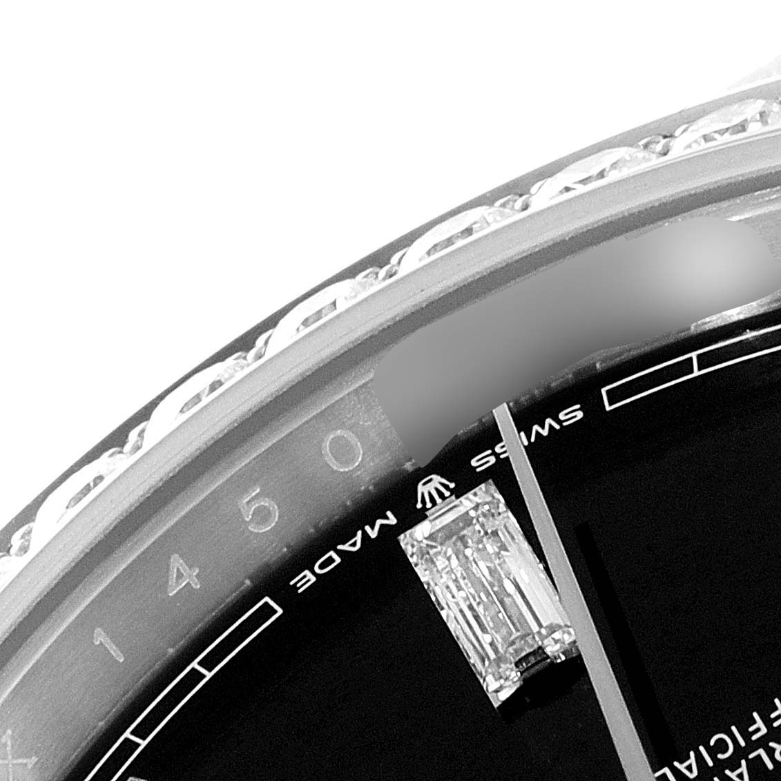 This close-up image shows part of the bezel and dial of the Rolex President 228349RBR Men's White Gold Black Dial 228349RBR Men's White Gold Black Dial model watch, featuring diamond detail and Swiss Made text.