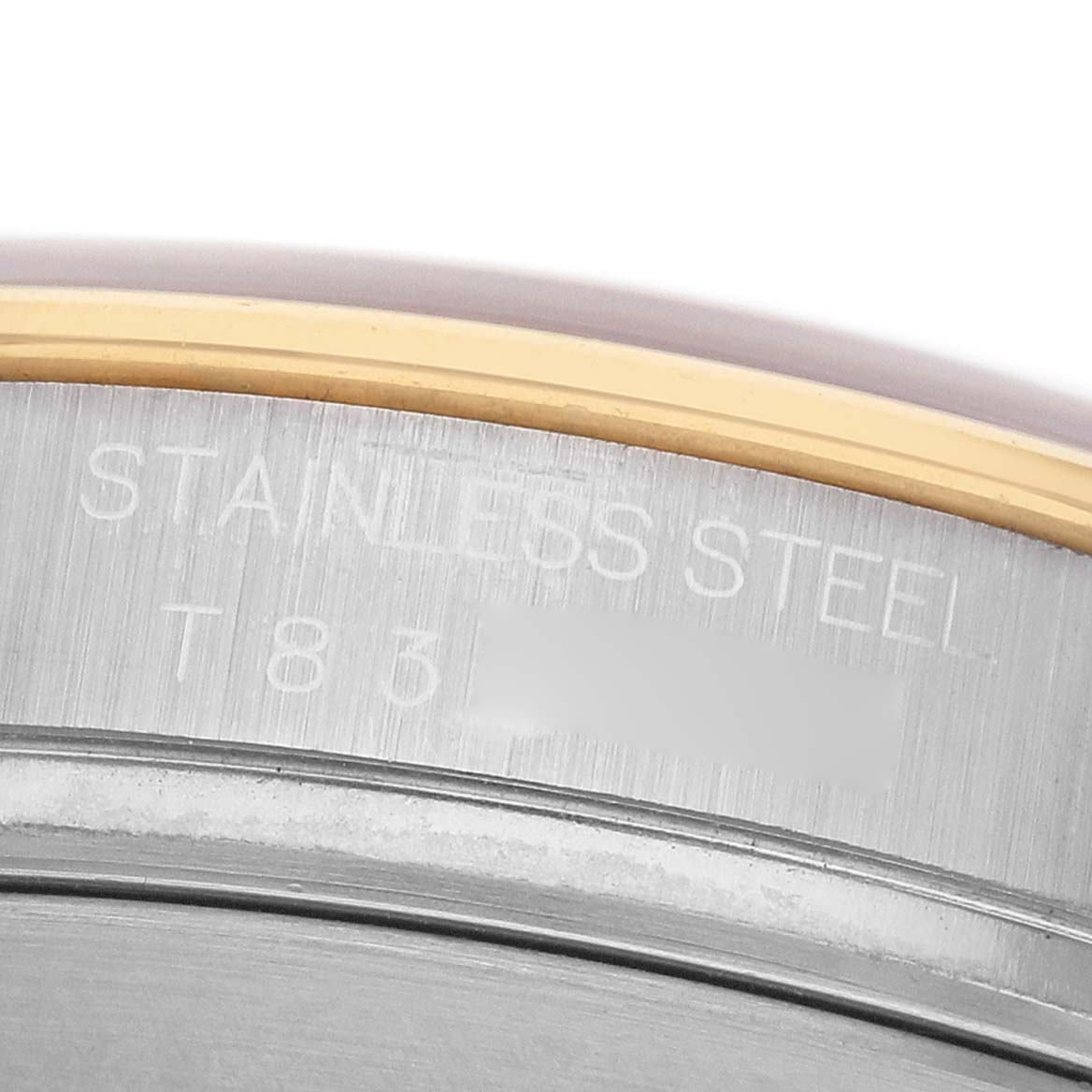 The image shows a close-up of the engraved side edge of a Rolex Daytona 16523 Men's Steel and Gold (two tone) Champagne Dial watch, highlighting the "STAINLESS STEEL" engraving.