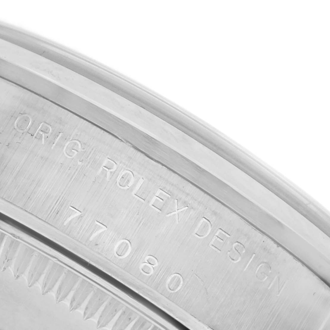The image shows a close-up of the engraved bezel or case edge of a Rolex Mid-Size 77080 Women's Stainless Steel Black Dial 77080 Women's Stainless Steel Black Dial watch, highlighting the model number and "Orig Rolex Design."