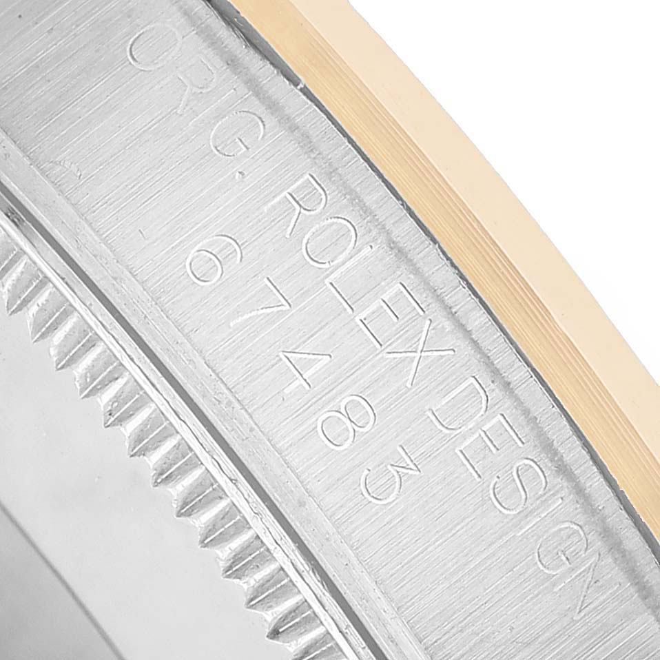 The image shows a close-up of the case side of the Rolex Oyster Perpetual 67483 Women's Steel and Gold (two tone) Black Dial, focusing on the engraved model number.