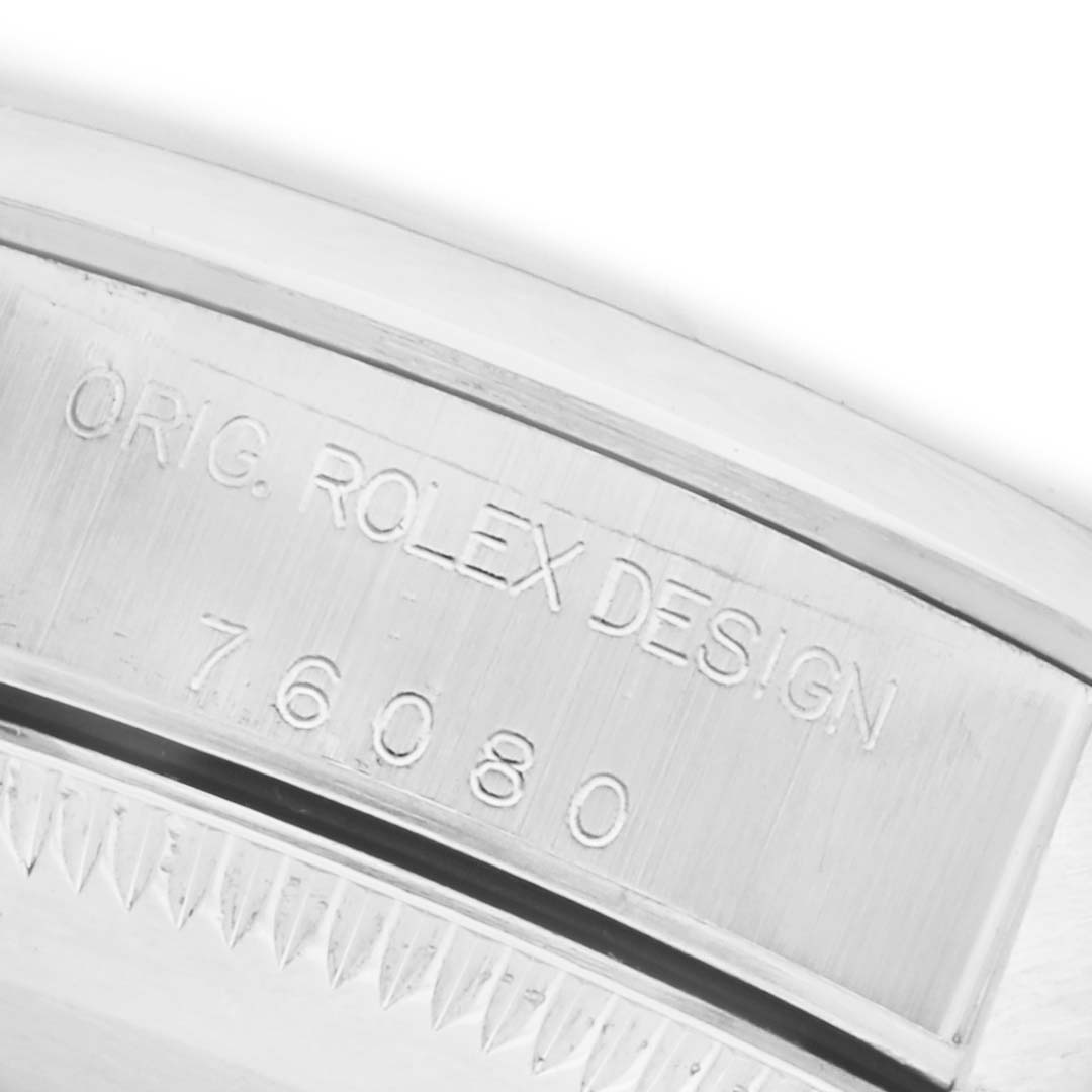 The image shows a close-up of the case side of a Rolex Oyster Perpetual 76080 Women's Stainless Steel Silver Dial 76080 Women's Stainless Steel Silver Dial, featuring the engraved model number and "ORIG. ROLEX DESIGN."