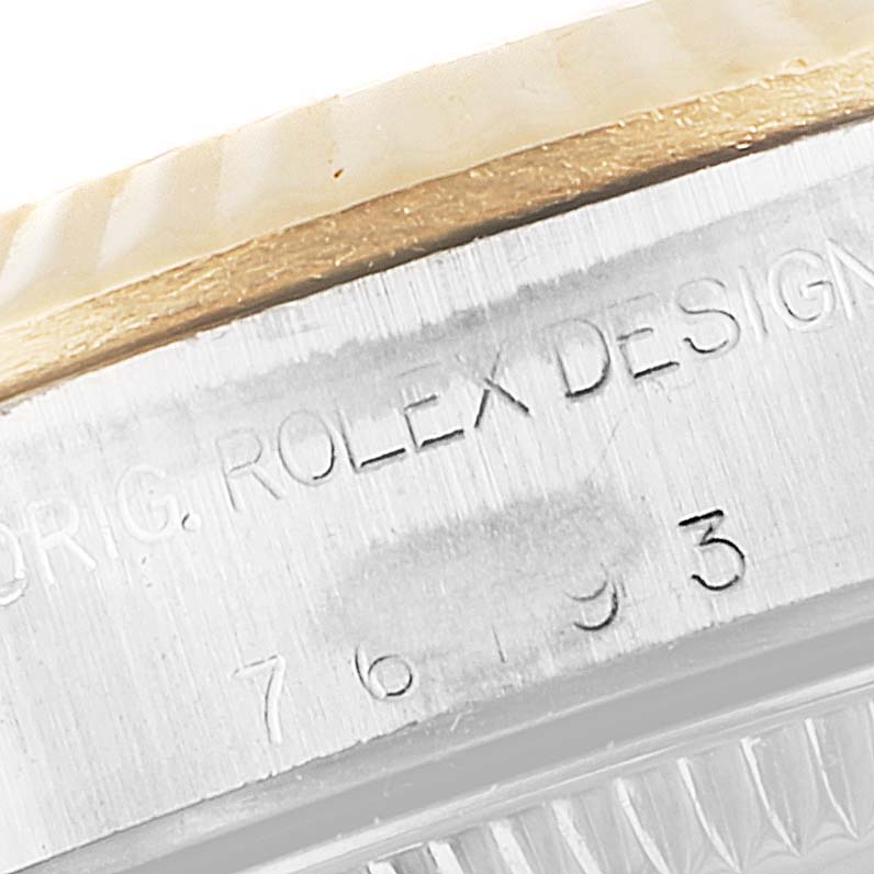 This is a close-up of the watch casing edge, showcasing the engraved model details of the Rolex Oyster Perpetual 76193 Women
s Steel and Gold (two tone) Champagne Dial 76193 Women
s Steel and Gold (two tone) Champagne Dial.