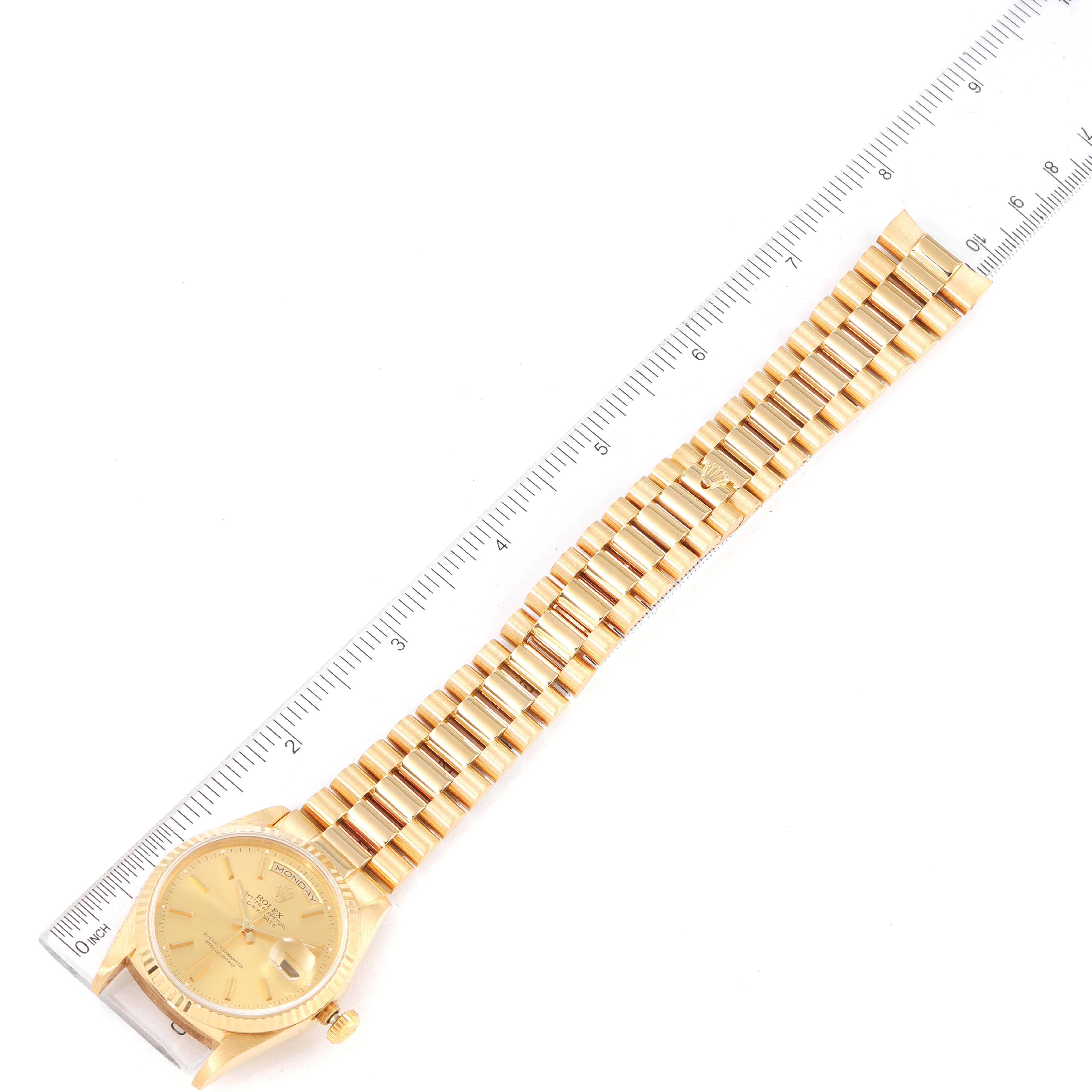 The Rolex President 18238 Men's Yellow Gold Champagne Dial 18238 Men's Yellow Gold Champagne Dial model watch is shown from a top-down angle, displaying the full band and part of the dial next to a ruler.
