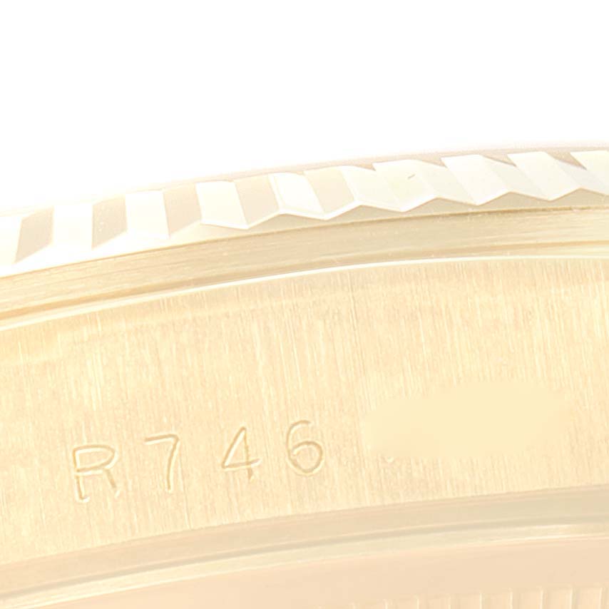 The image shows a close-up of the engraved edge and part of the fluted bezel of a Rolex President 18238 Men's Yellow Gold Champagne Dial 18238 Men's Yellow Gold Champagne Dial model watch.