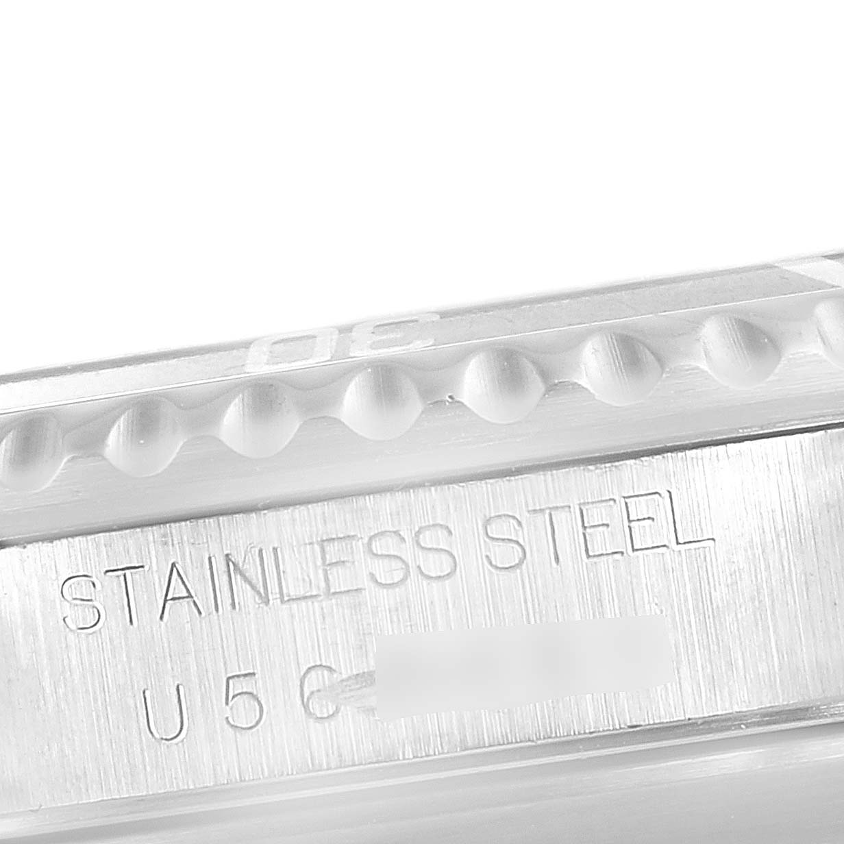 The image shows a close-up angle of the side of a Rolex Submariner 14060 Men's Stainless Steel Black Dial 14060 Men's Stainless Steel Black Dial watch with the engraving "STAINLESS STEEL."