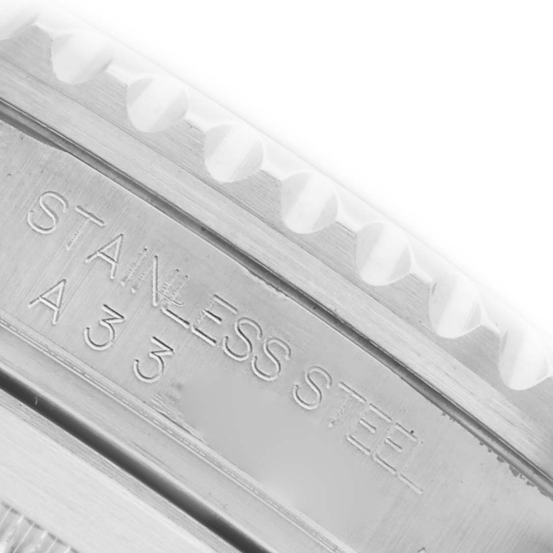 The image shows a close-up of the Rolex Submariner 16610 Men's Stainless Steel Black Dial 16610 Men's Stainless Steel Black Dial's engraved inner bezel, highlighting "STAINLESS STEEL A 3 3".