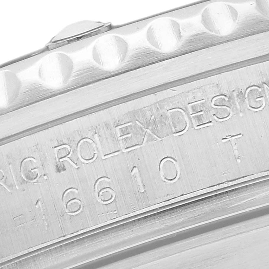 The image shows a close-up of a Rolex Submariner 16610 Men's Stainless Steel Black Dial 16610 Men's Stainless Steel Black Dial model's bezel and serial number engraving on the case.