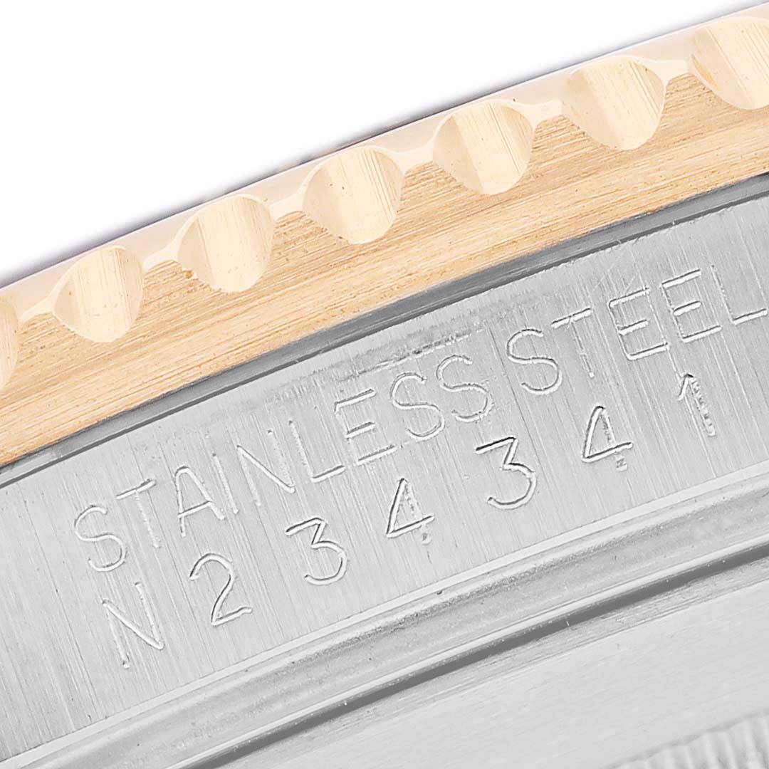 The image shows a close-up of the engraved stainless steel case back edge of a Rolex Submariner 16613 Men's Steel and Gold (two tone) Black Dial watch.