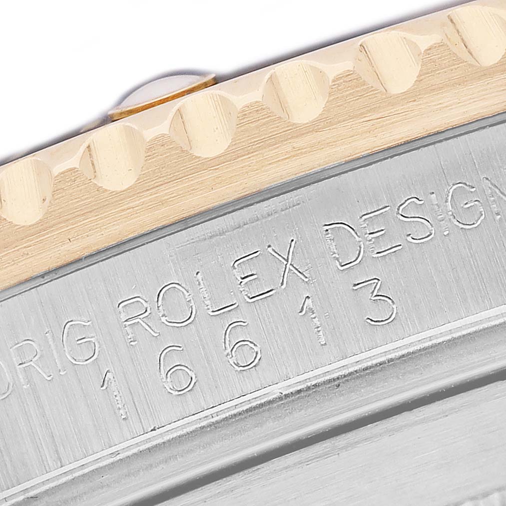 The image shows a close-up view of the bezel and engraved serial number on a Rolex Submariner 16613 Men's Steel and Gold (two tone) Black Dial watch.