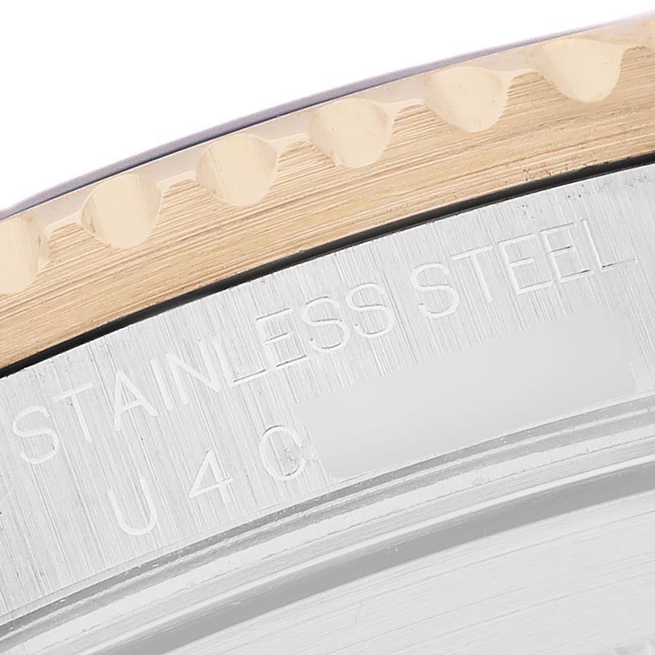 The image shows a close-up of the Rolex Submariner 16613 Men's Steel and Gold (two tone) Blue Dial's edge, featuring the bezel and case with engraved text.