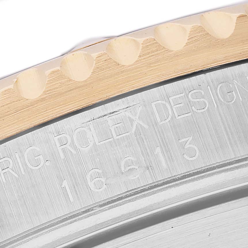 The image shows a close-up angle of the Rolex Submariner 16613 Men's Steel and Gold (two tone) Blue Dial's bezel edge and engraved case side.