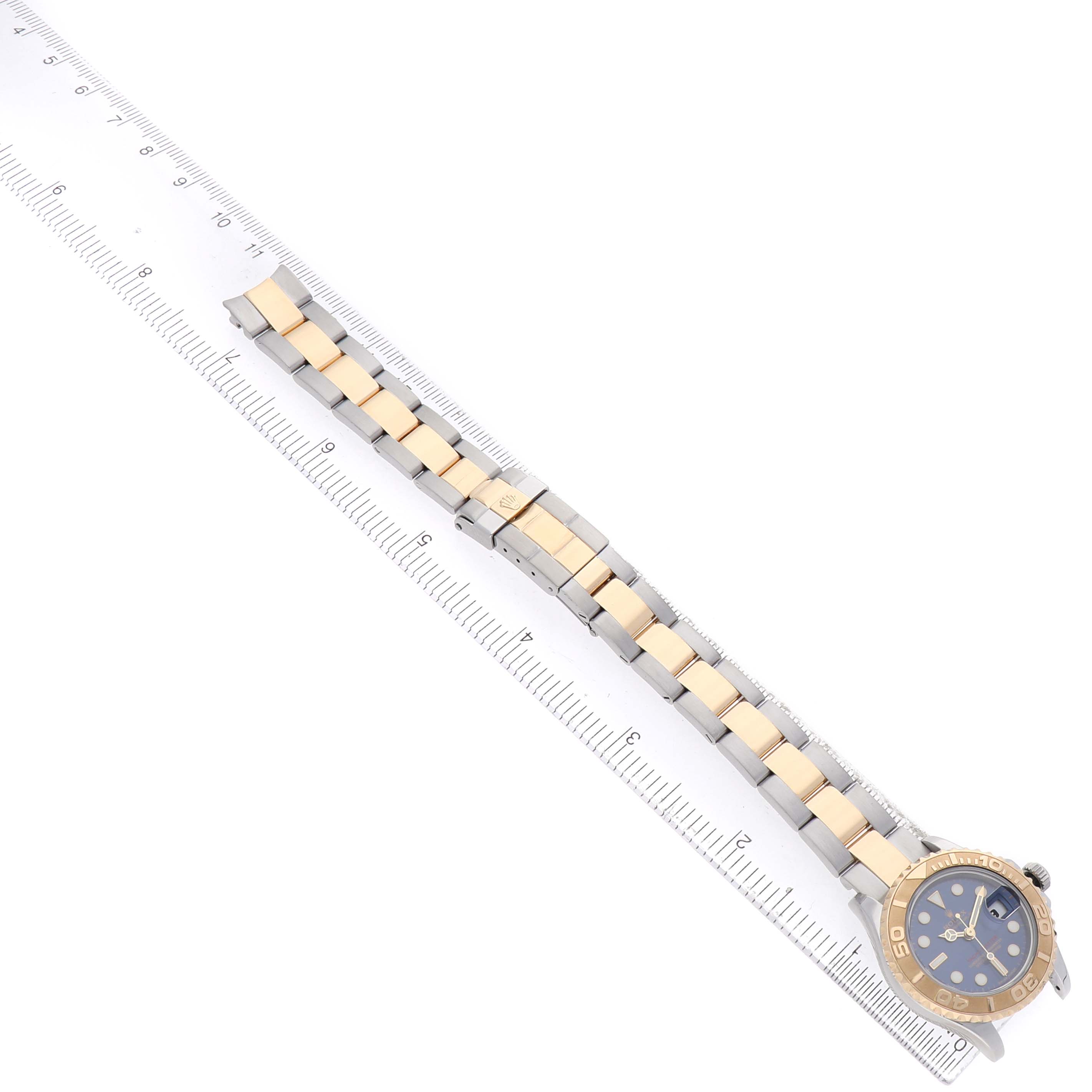 The Rolex Yacht-Master 169623 Women's Steel and Gold (two tone) Blue Dial watch is shown laid flat, with its bracelet and case visible, next to a ruler for measurement.
