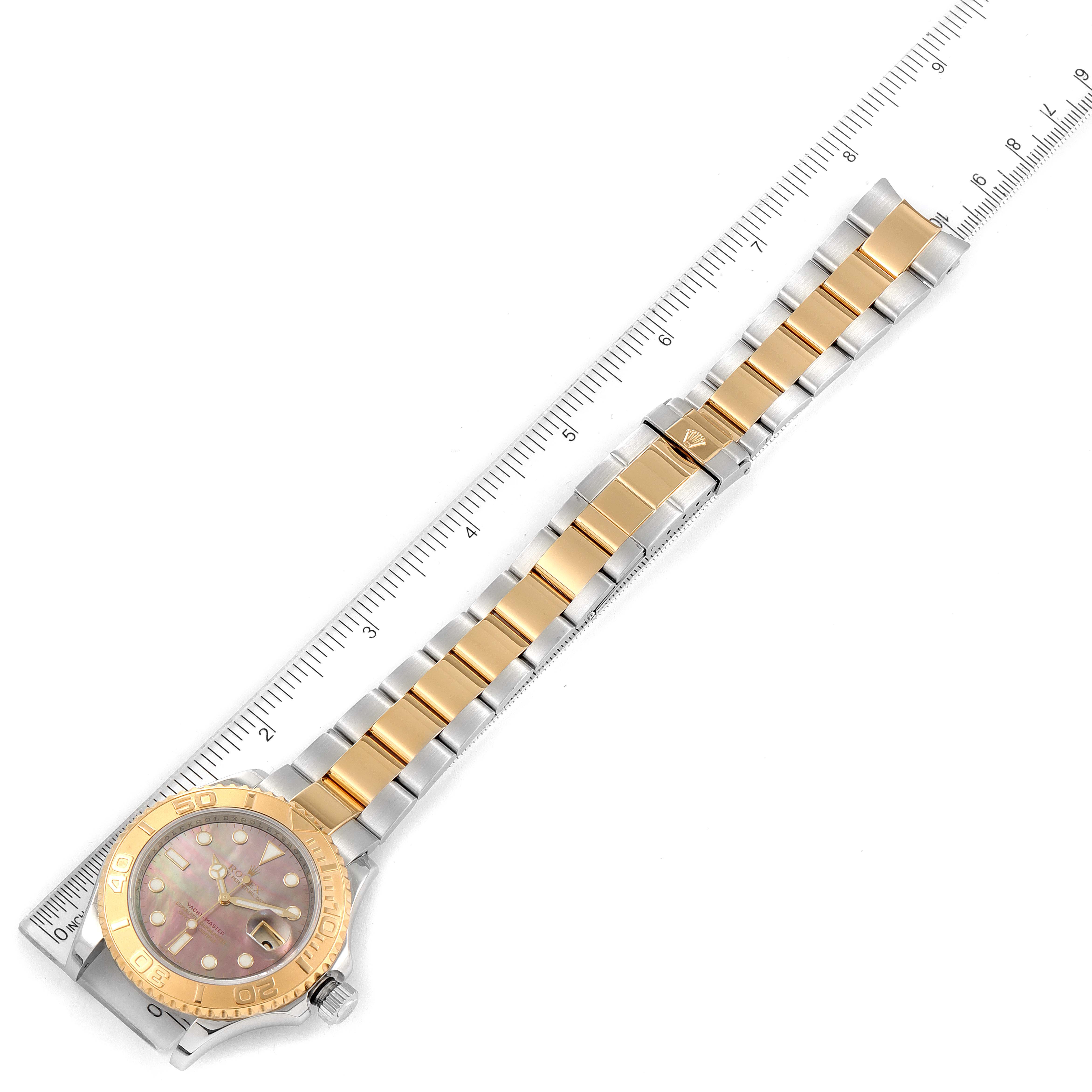 The image shows a Rolex Yacht-Master 16623 Men's Steel and Gold (two tone) Mother of Pearl Dial 16623 Men's Steel and Gold (two tone) Mother of Pearl Dial watch laid flat with its face, bracelet, and clasp visible, positioned alongside a ruler.