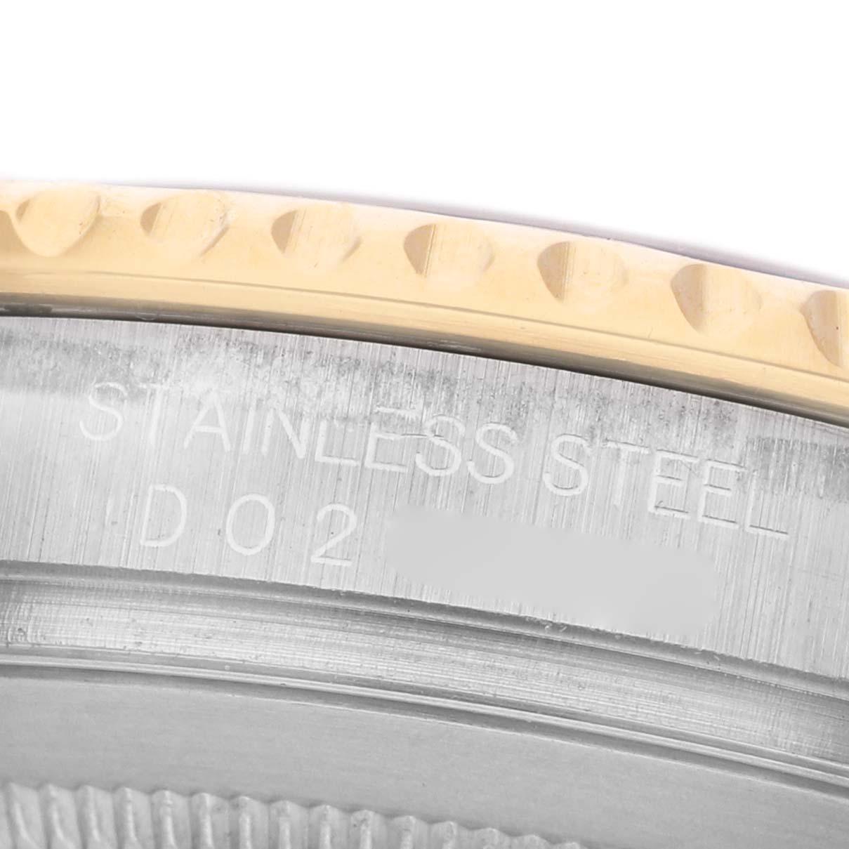The image shows the side view of a Rolex Yacht-Master 77099 Men's Steel and Gold (two tone) Champagne Dial, focusing on the engraved stainless steel watch case and a part of the bezel.