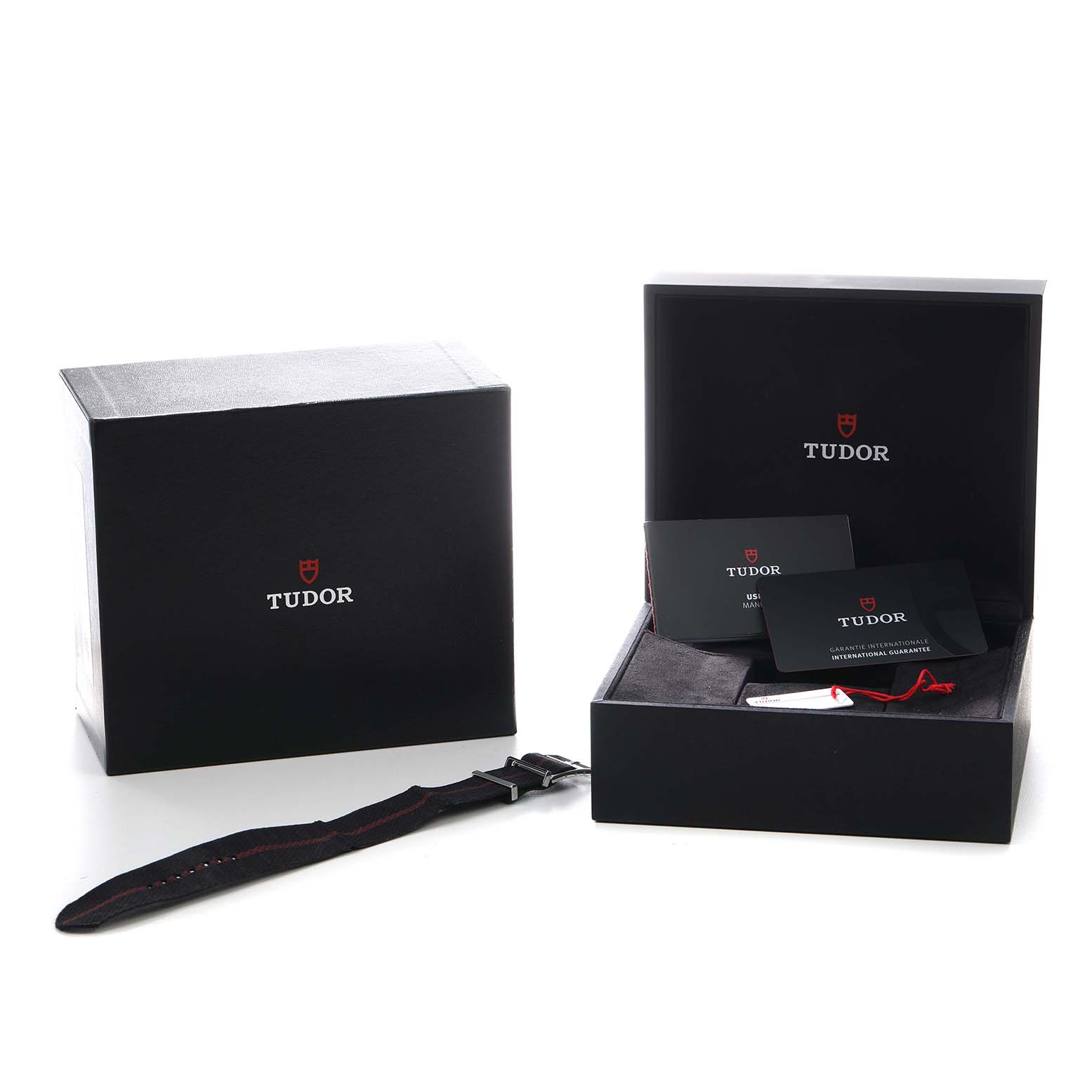 The image shows Tudor Heritage Chrono 79360 Men's Stainless Steel Silver Dial packaging and accessories, including boxes, a strap, booklets, and a tag from a frontal angle.