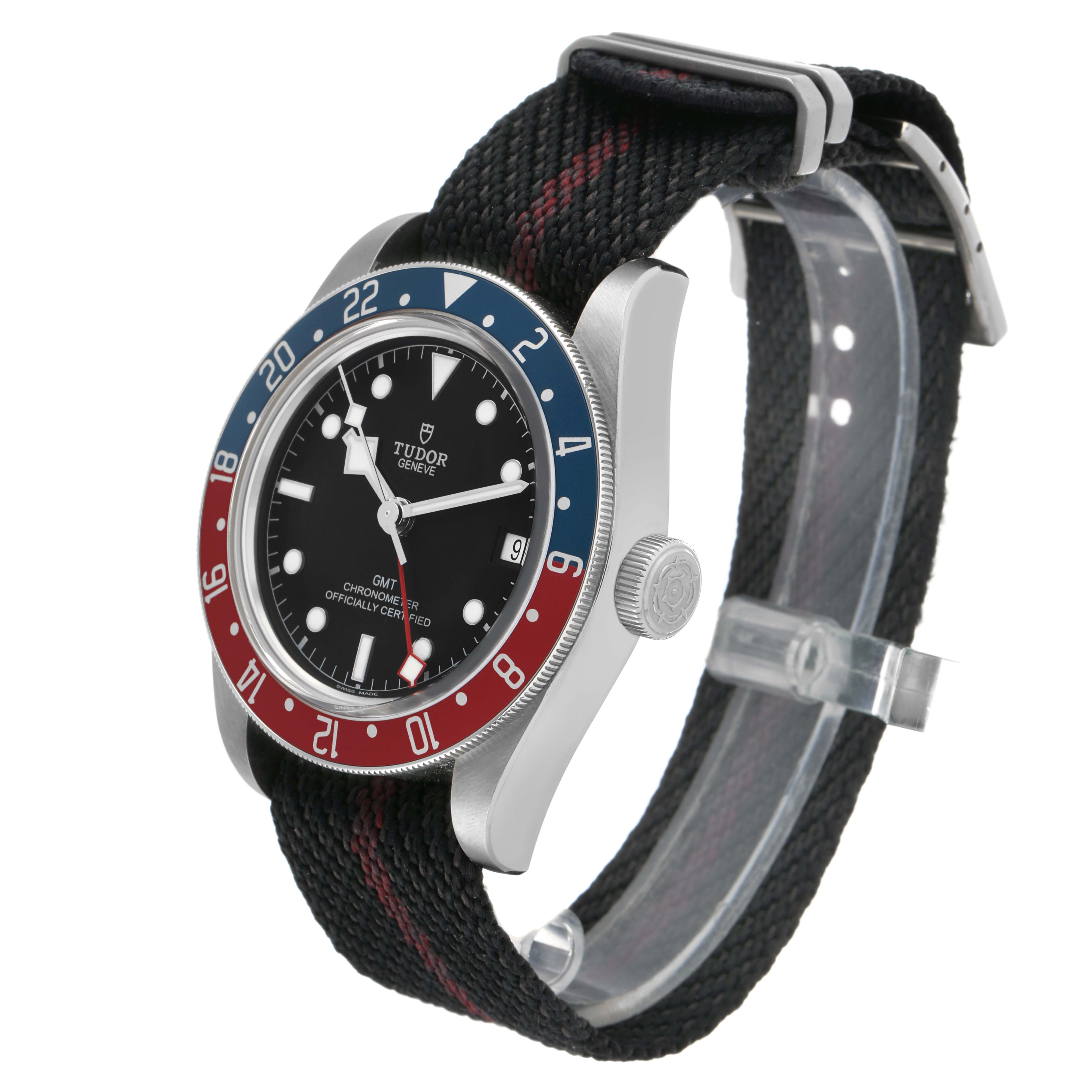 The Tudor Heritage Black Bay 79830RB Men's Stainless Steel Black Dial watch is shown at a three-quarter angle, highlighting its face, bezel, crown, and fabric strap.