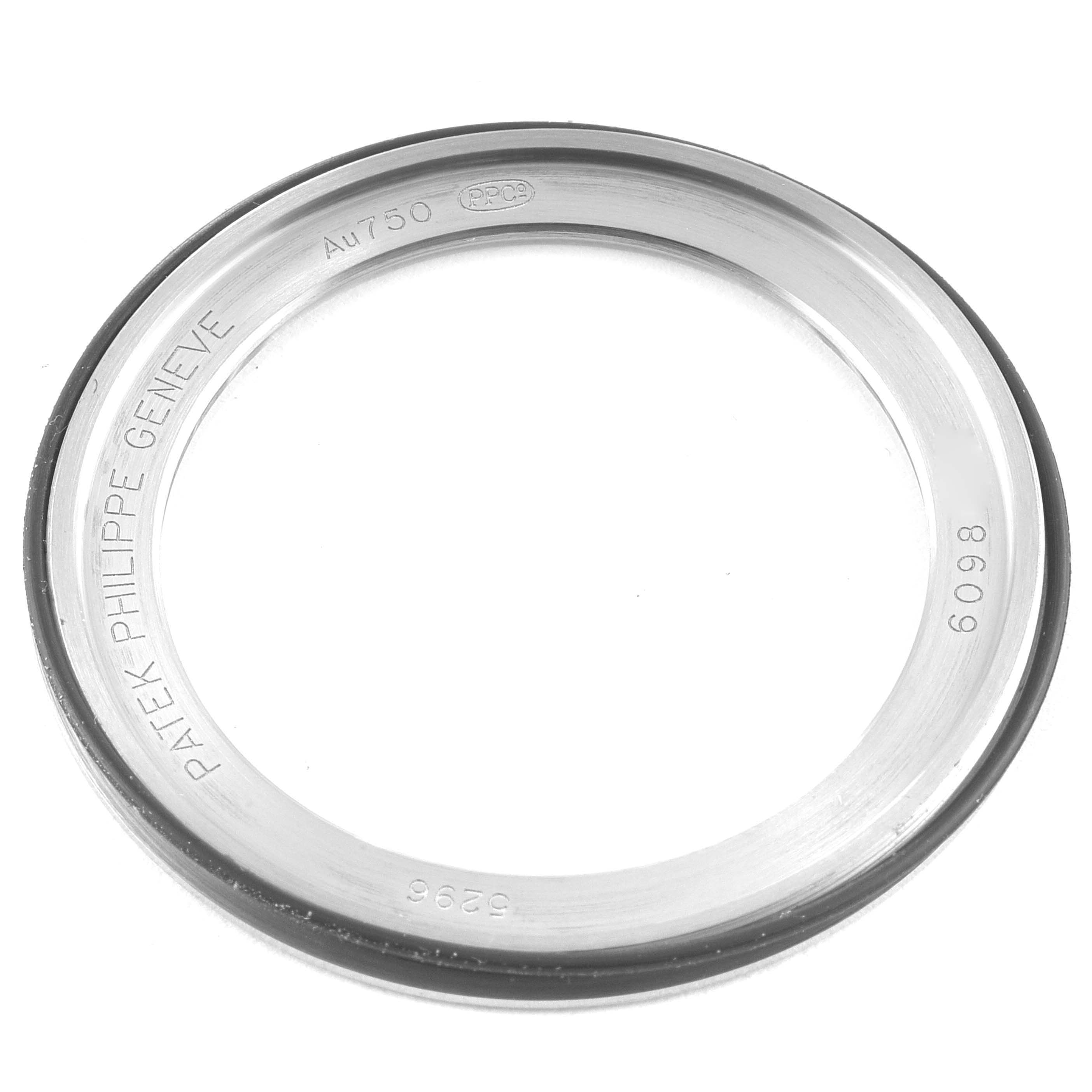 This image shows a Patek Philippe Calatrava 5296G Men's White Gold Silver Dial 5296G Men's White Gold Silver Dial watch bezel viewed from above, displaying engravings and markings.