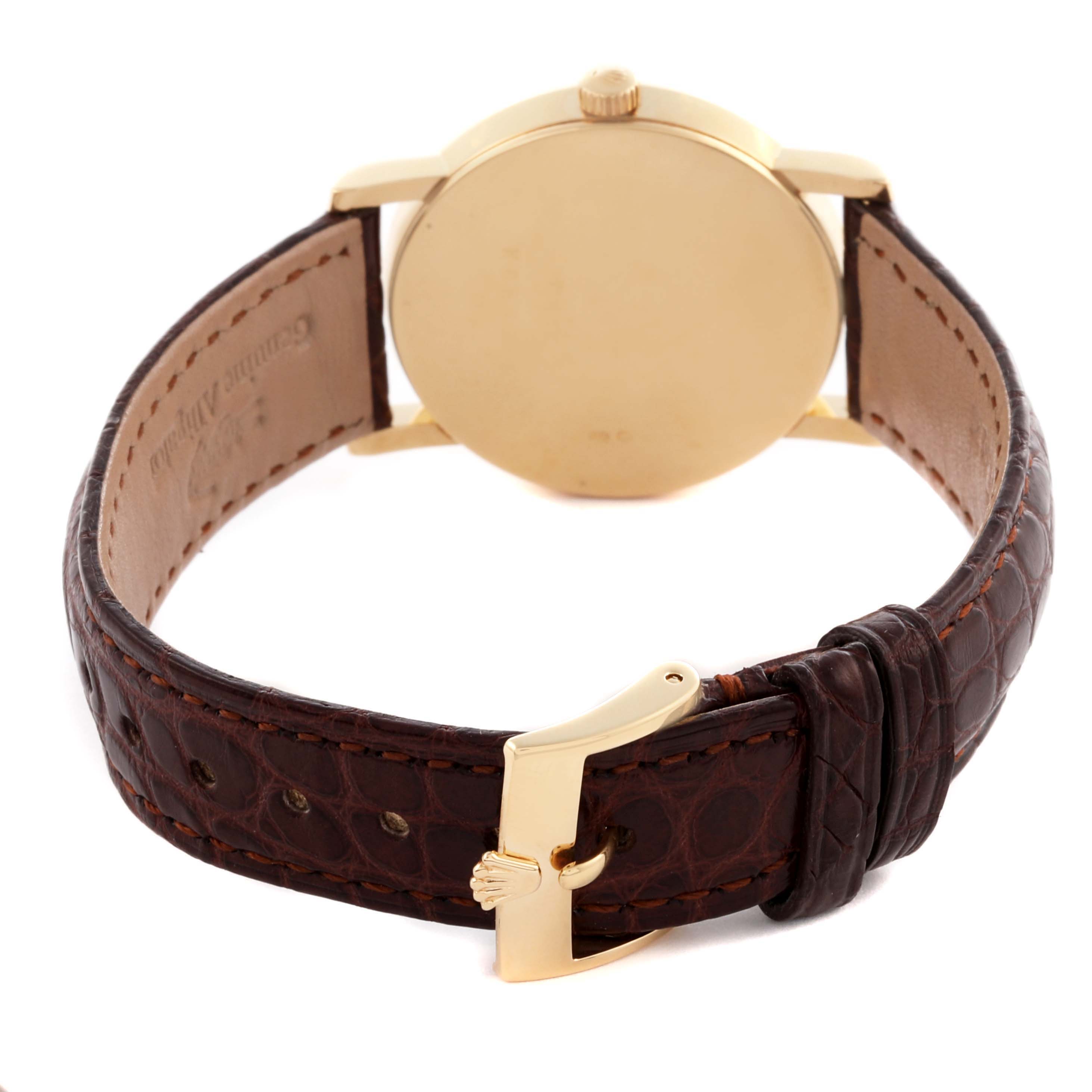 The Rolex Cellini 5115 Men's Yellow Gold Silver Dial 5115 Men's Yellow Gold Silver Dial watch is shown from the back, highlighting its leather strap and gold buckle.