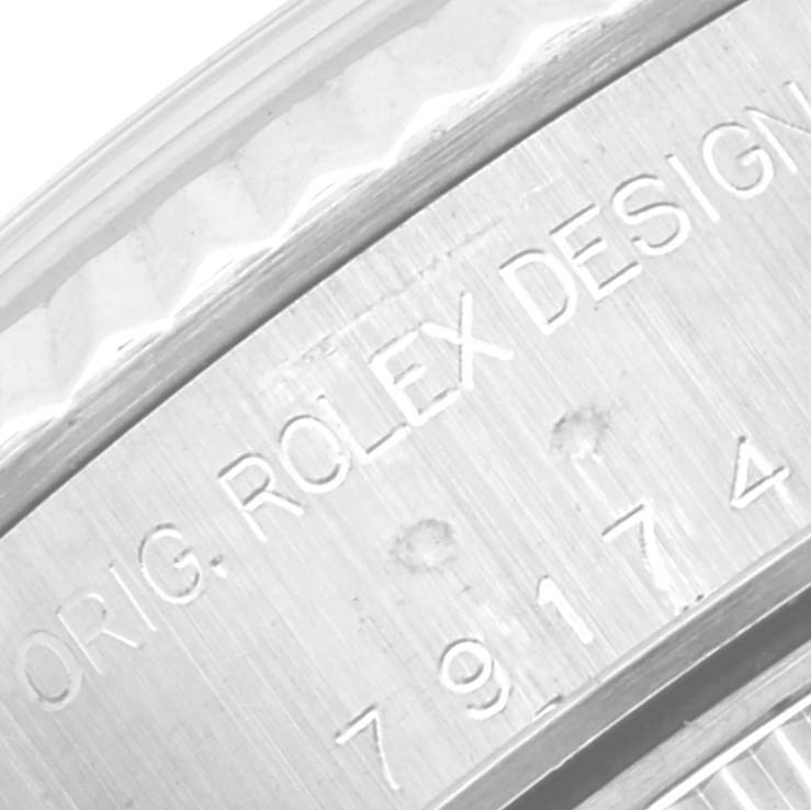 This image shows a close-up of the engraved text on the metal case back of a Rolex Datejust 79174 Women's Stainless Steel Silver Dial 79174 Women's Stainless Steel Silver Dial watch.