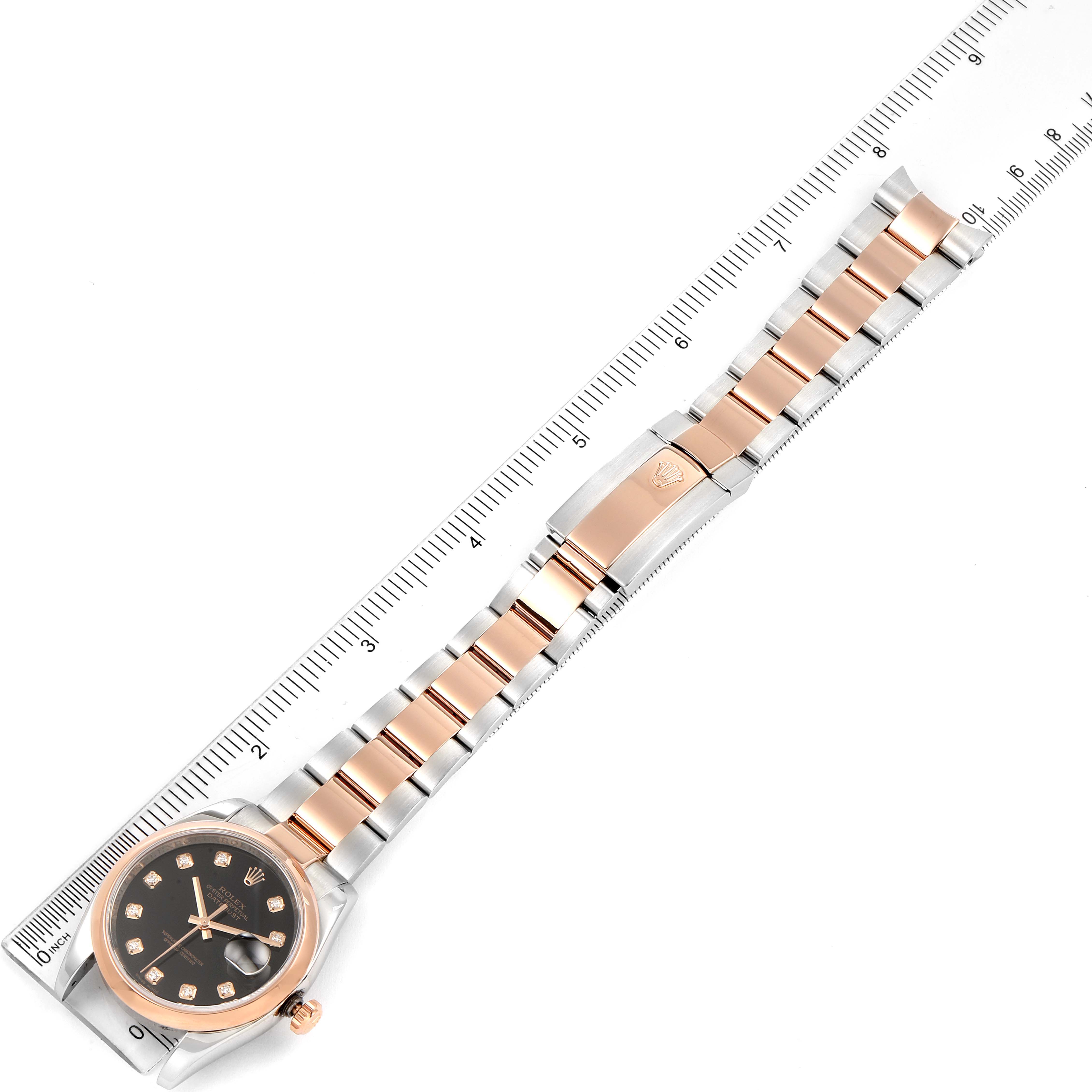 This image shows a top view of a Rolex Datejust 116201 Men
s Rose Gold Black Dial 116201 Men
s Rose Gold Black Dial watch, featuring its dial, bezel, and full bracelet next to a ruler for scale.