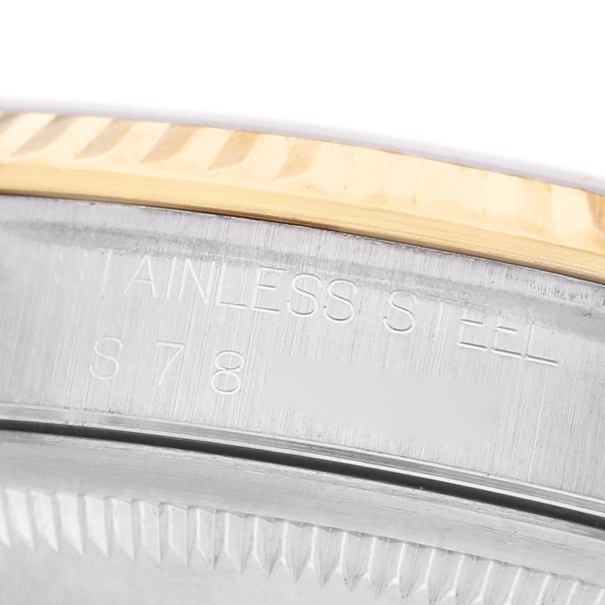 The image shows a close-up of the side of a Rolex Datejust 16233 Men's Steel and Gold (two tone) White Dial watch, highlighting the stainless steel with engraved text and a gold fluted bezel.